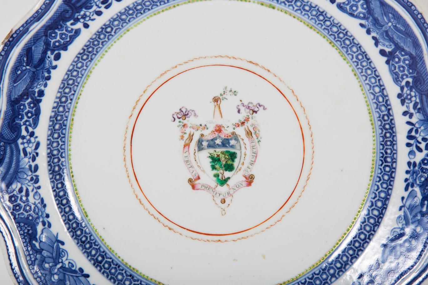 This Chinese export porcelain plate features a blue on white Fitzhugh style border surrounding an armorial containing the motto 