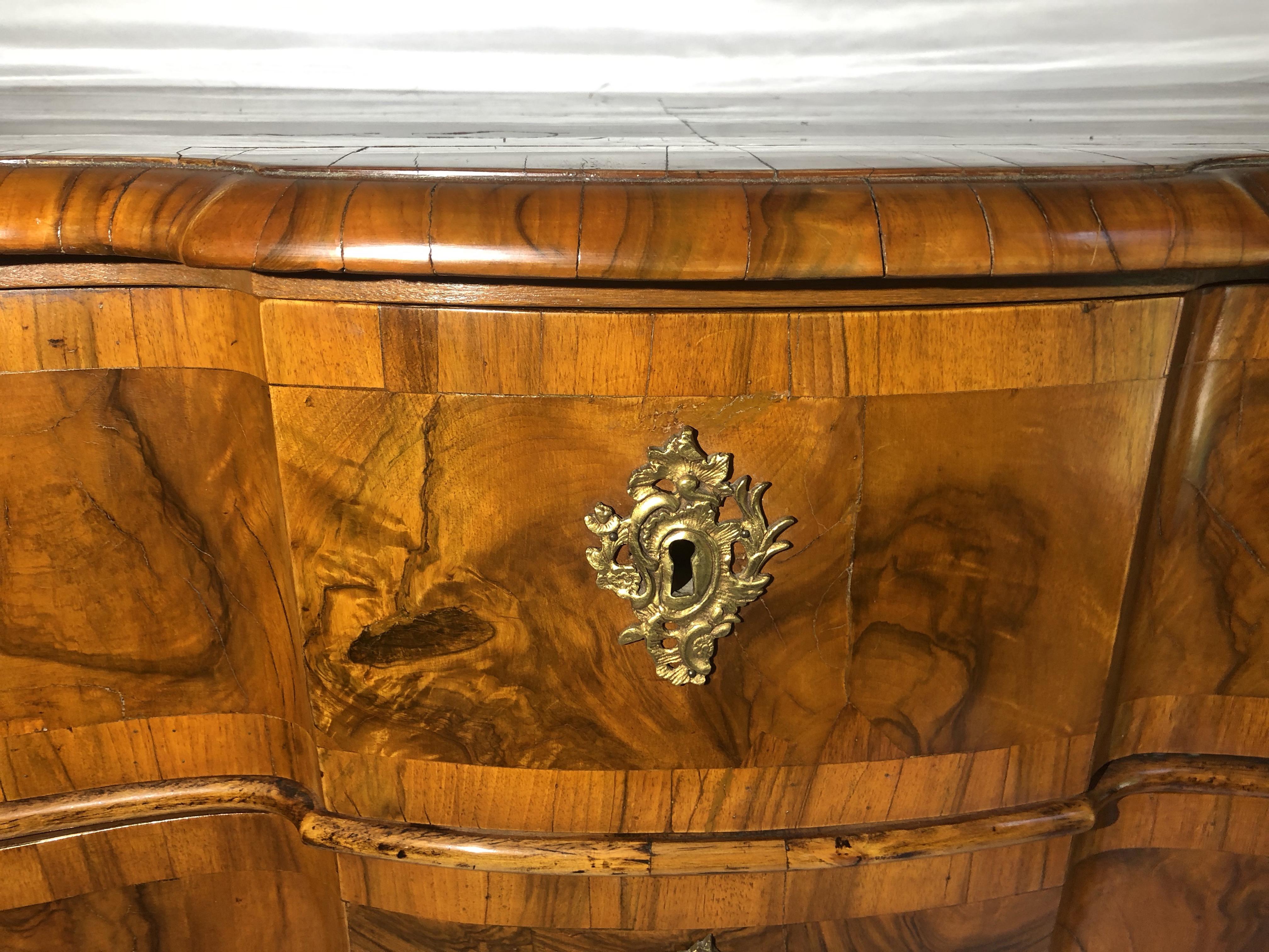 Mid-18th century high gloss Rococo walnut serpentine front, gilt bronze mounted three-drawer chest with bracket feet, original hardware, and satiny lustrous patina. Exquisite shine to the wood.  A perfect focal point in any entrance hall with a
