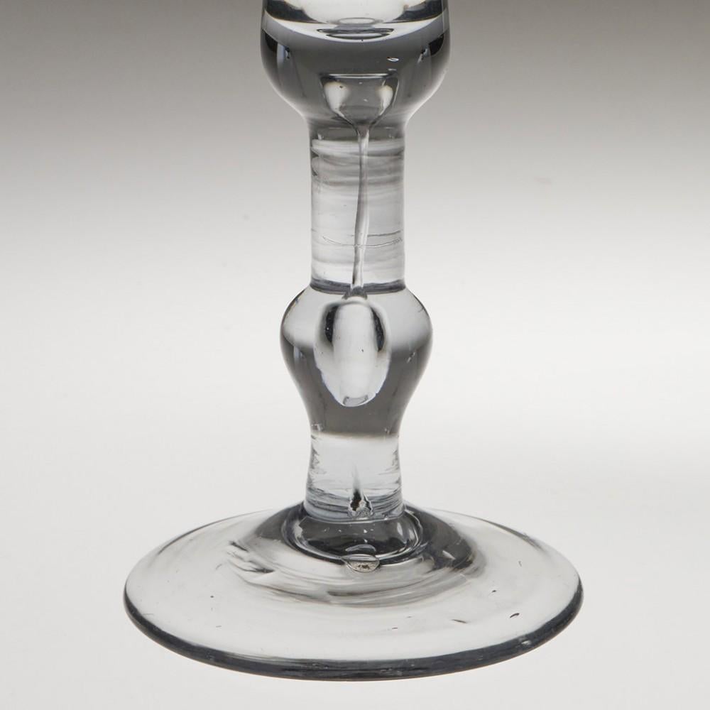 Heading : Baluster stem wine glass
Period :  1730 - 1777
Origin : England or possibly Norway
Colour : Clear with pronounced dark grey hue
Bowl : Bell with thickened base containing air tear
Stem : Inverted baluster - air tear which swells in both