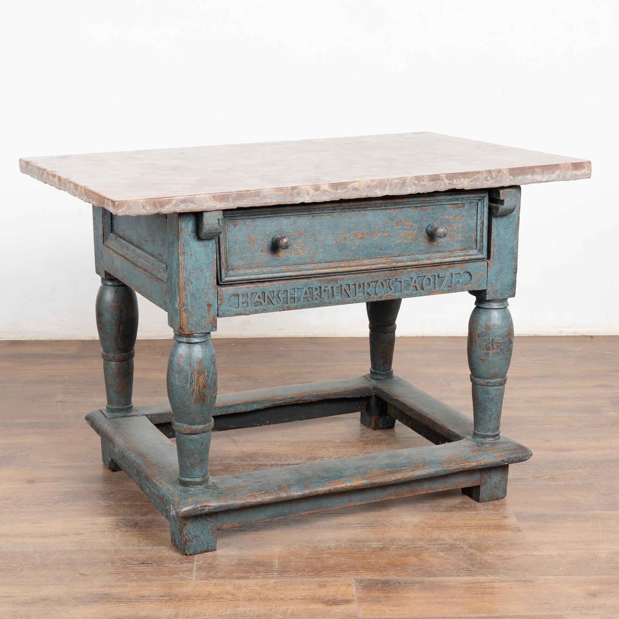 Cette belle table baroque en chêne à plateau en pierre comporte un tiroir, des pieds fortement tournés et de jolis châssis inférieurs. La finition peinte en bleu présente des signes de détérioration et d'usure qui révèlent le bois de chêne naturel