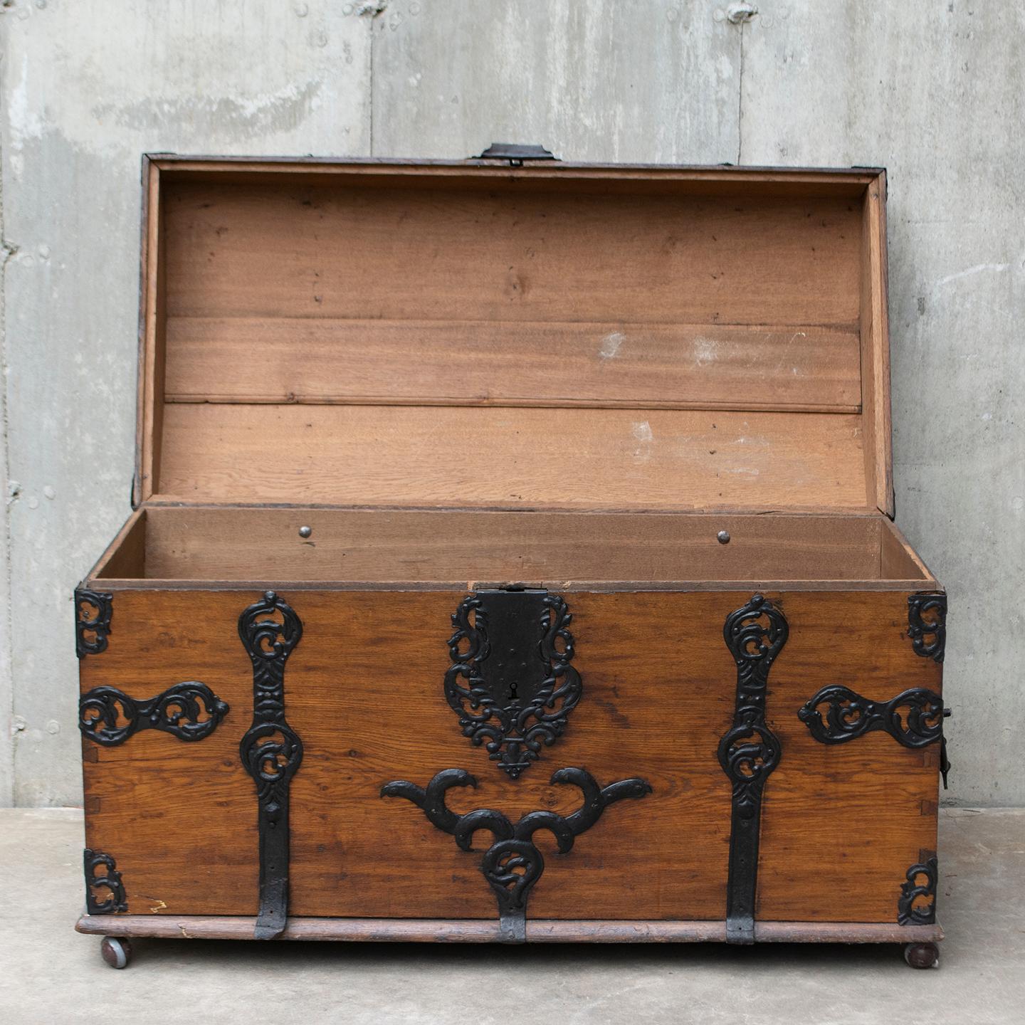 This large domed 18th Century Baroque Chest is made with solid oak and mounted with decorative iron strapwork and handles. It is a handsome example of immigrant trunks that were made in Germany from the 1600’s to the 1800’s. The warm natural color