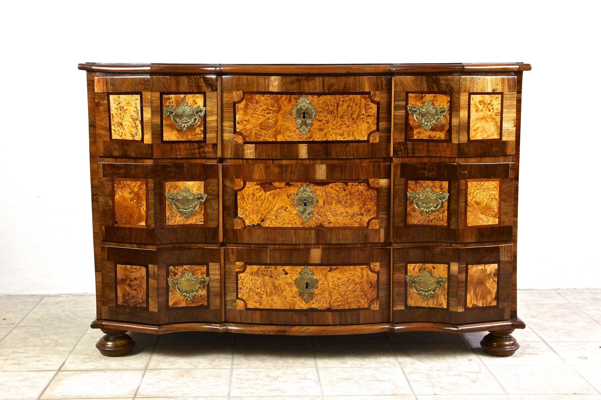 Outstanding baroque chest of drawers from the period in Austria around 1770. An absolutely beautiful late 18th century chest of drawers showing an exceptional design combining straight lines with soft curved shapes. The fine nut wood veneered