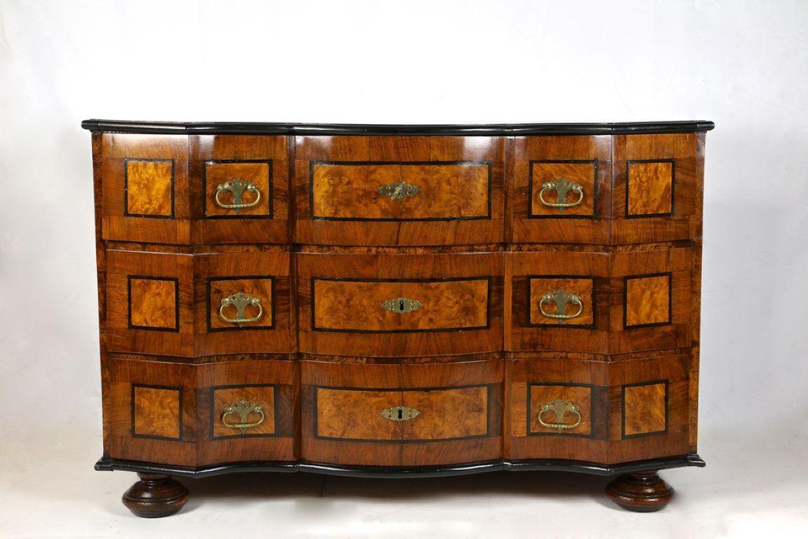 Remarkable baroque chest of drawers from the period in Austria around 1770. A fantastic late 18th century chest of drawers showing an extraordinary design combining straight lines with soft curved shapes. The fine nut wood veneered surface with