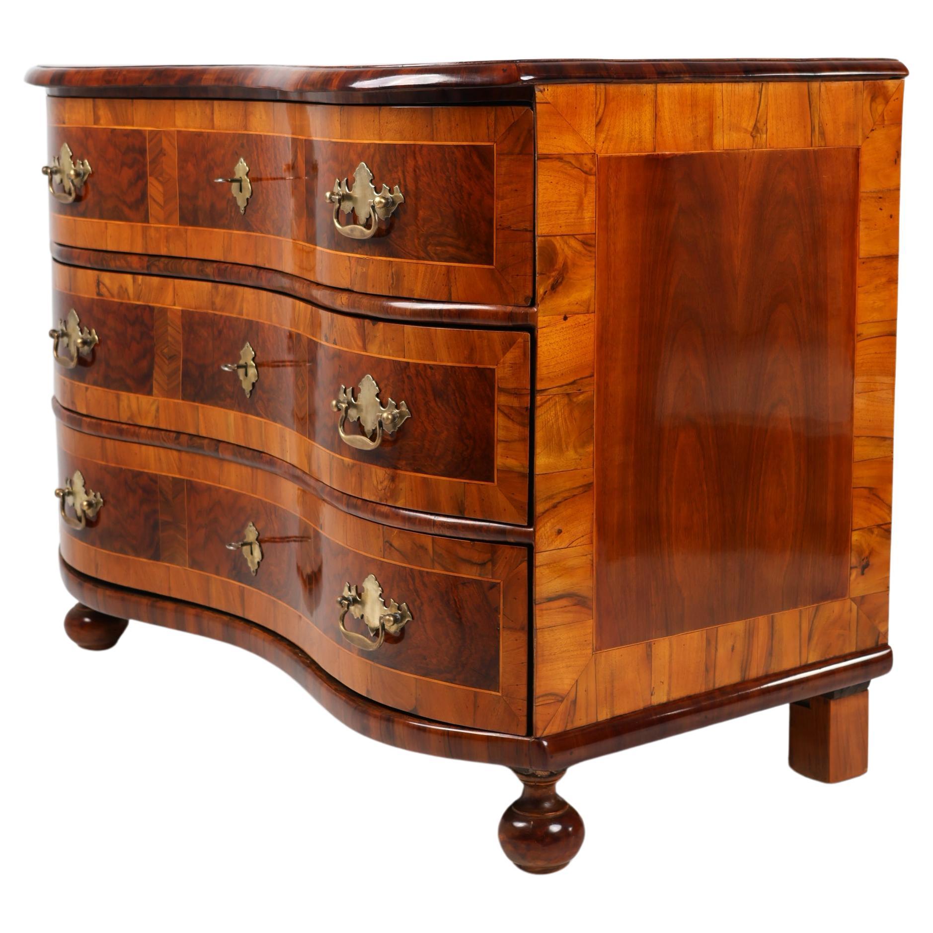 Cassettiera barocca,
Germania ca. 1760
Noce

Cassettiera barocca in noce con superficie intarsiata del 1760. Questa cassettiera antica ha tre cassetti e colpisce per il suo dettagliato design barocco. Realizzato in legno di noce di alta qualità,