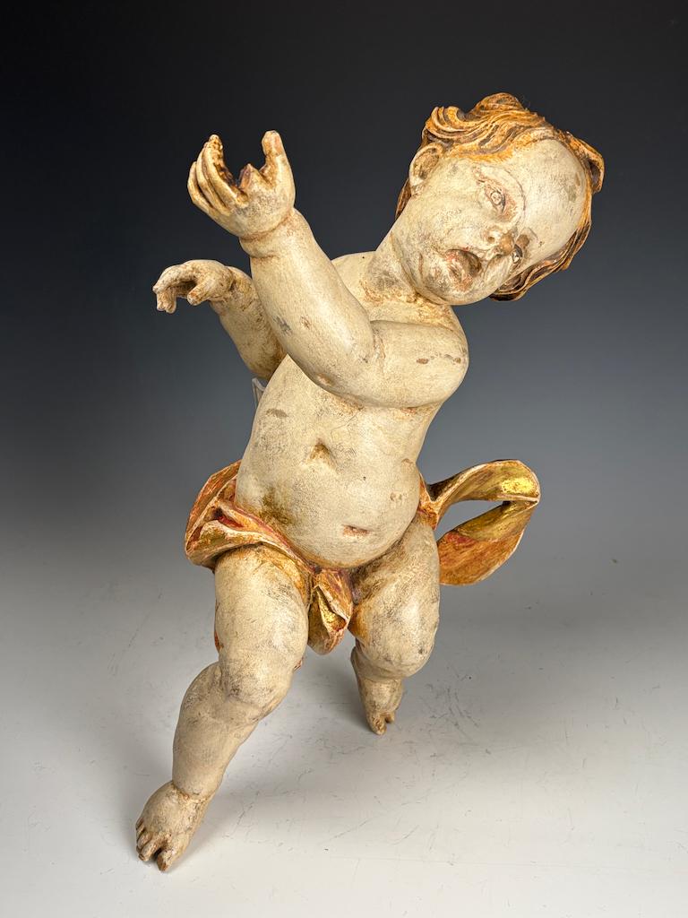 Putto baroque en bois doré du 18e siècle - Chérubin antique sculpté et peint à la main

Ce remarquable putto baroque en bois doré du XVIIIe siècle est un bel exemple d'art ecclésiastique de la fin de la période baroque, méticuleusement sculpté à la