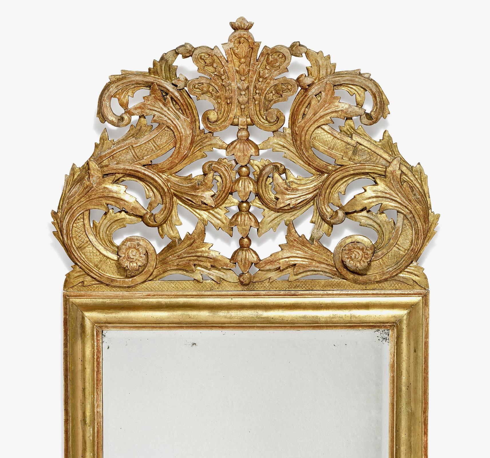 Un beau miroir baroque en bois doré, probablement suédois, de grandes proportions, en bon état d'origine. Le grand miroir est d'origine, avec des bords facettés et une belle couleur. La dorure est d'origine et présente une belle patine quelque peu