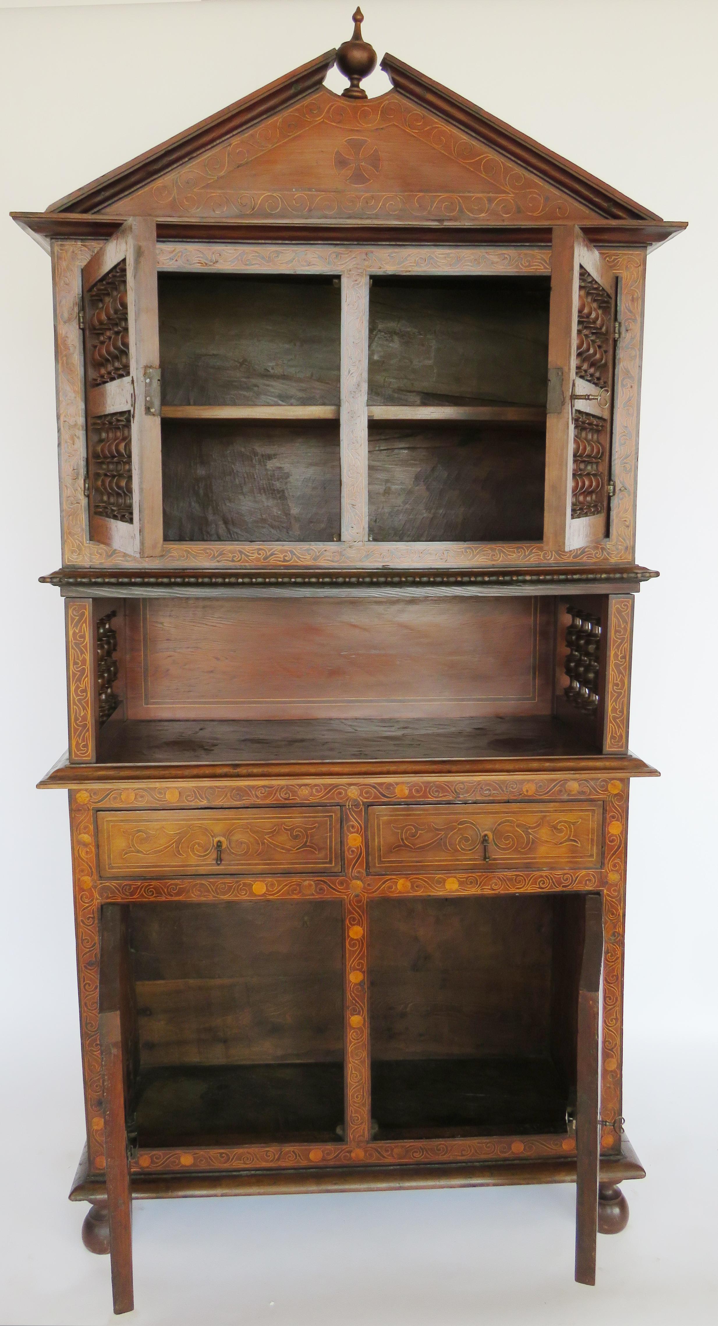 Three storied lemon inlaid marquetry cabinet. Upper storey has a peaked pediment over double doors with turned spindles on front and sides. Special attention to the minute scrolling inlay on door surrounds. Middle storey has a rectangular fluted top