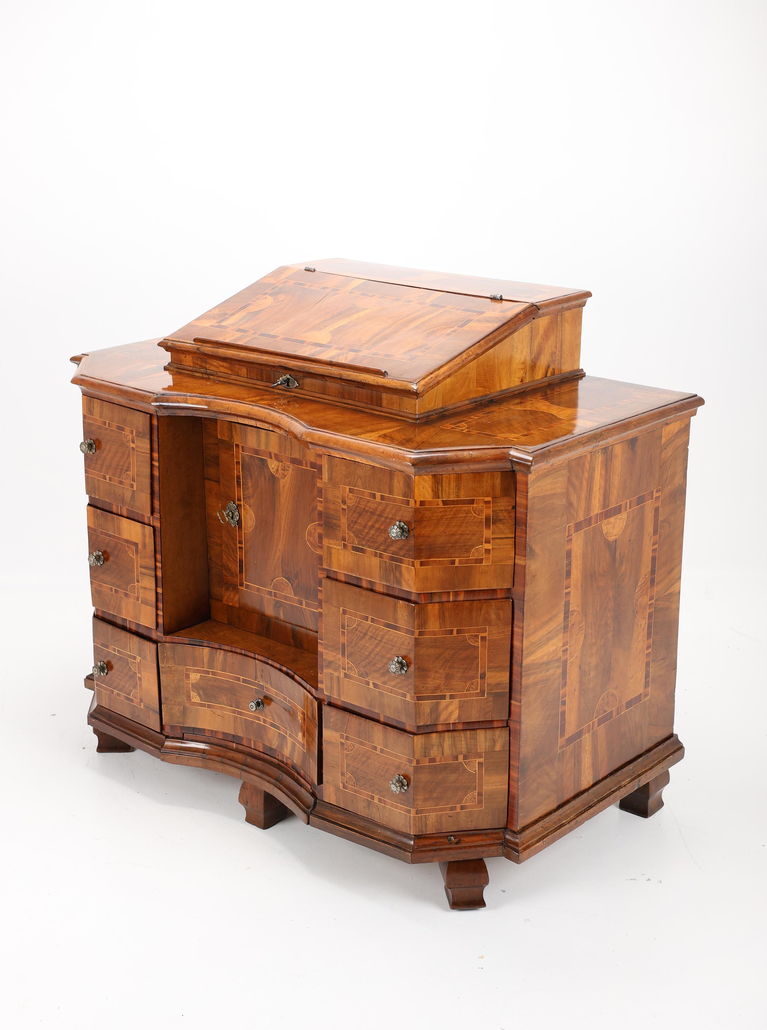 Exquisita cómoda barroca de nogal del siglo XVIII - Finamente incrustada y pulida a mano
1750, Alemania

Este magnífico baúl barroco del siglo XVIII es una auténtica obra maestra de artesanía. Fabricada con nogal de primera calidad y fina chapa de