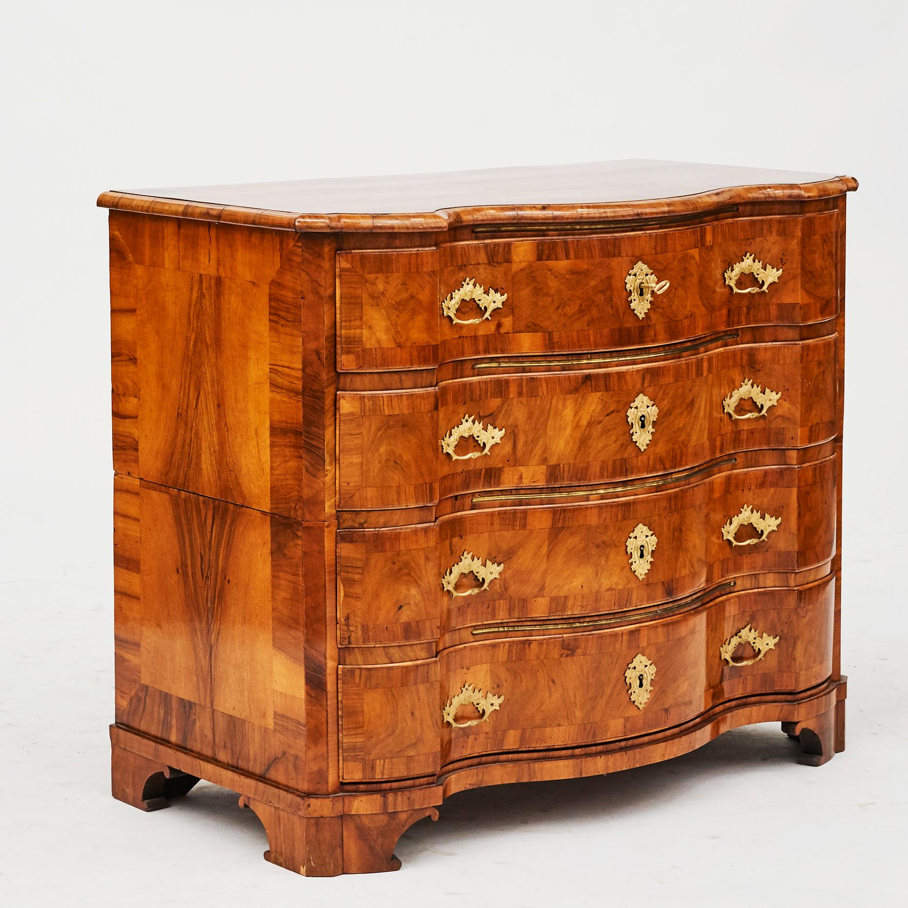 Baroque chest of drawers. Richly carved serpentine front and curvaceous top. Oak beautifully veneered with walnut. Brass moldings between each drawer, Denmark, circa 1730-1740.