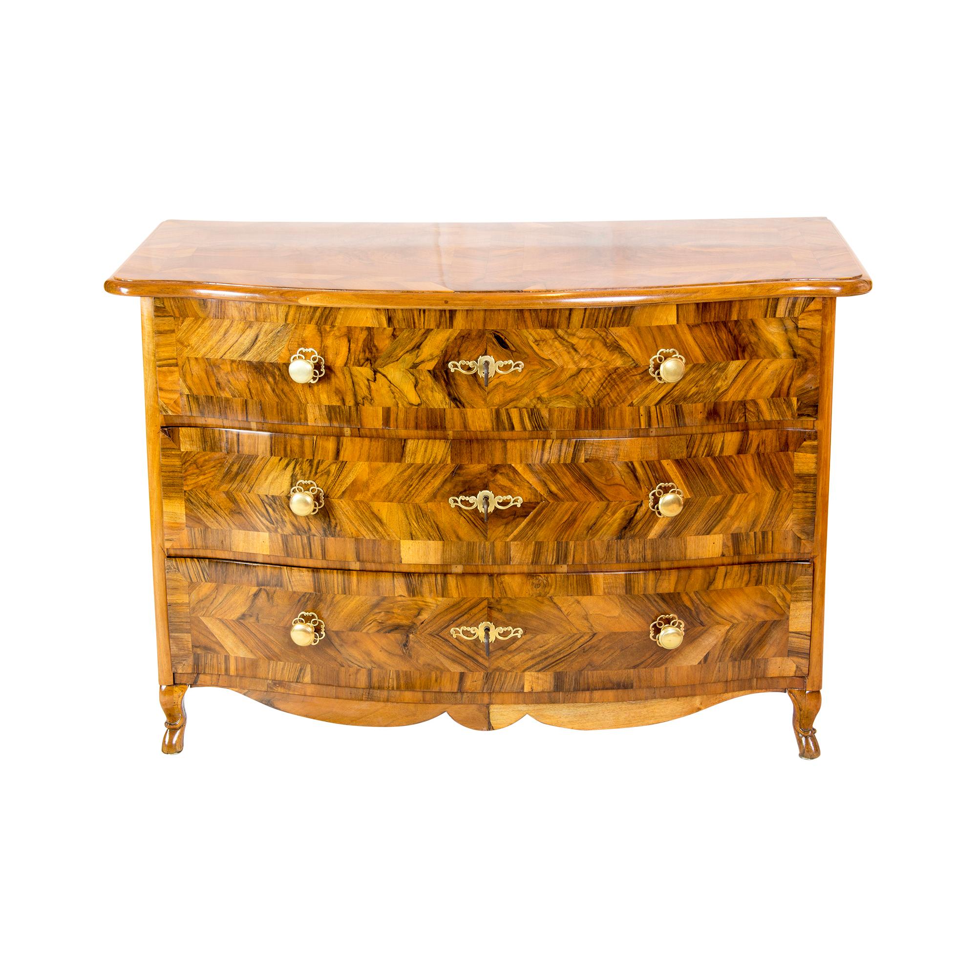 The baroque chest of drawers dates from the 18th century. The front and the lid of the chest of drawers are veneered with walnut marquetry on spruce. The sides are solid walnut. The locks and the fittings are original. The locks are functional. The