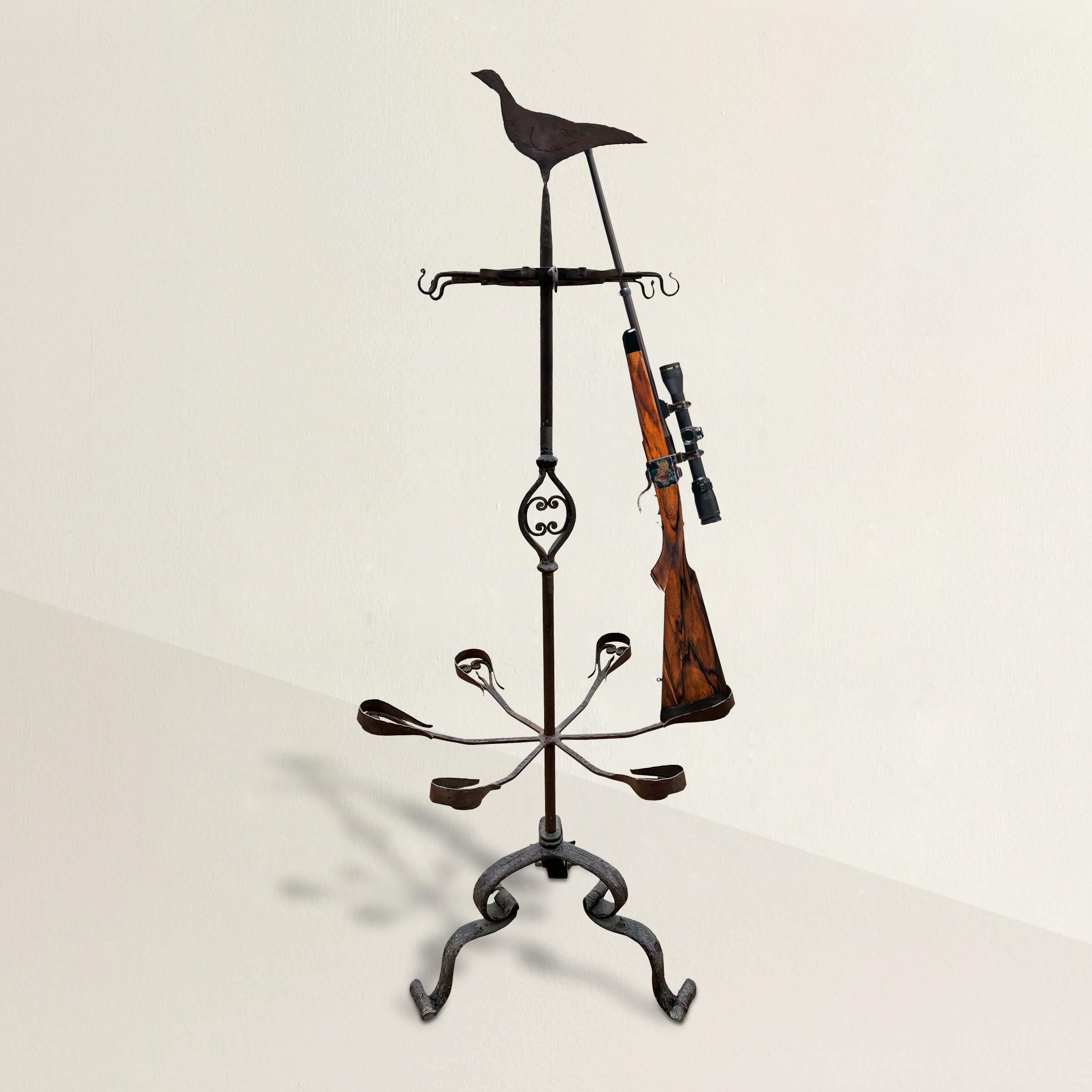 An incredible and rare 18th century Belgian wrought-iron gun rack from a hunting lodge in Southern Belgium designed for use at hunting parties. A silhouetted game-bird sits on the top. The rack has six arms to cradle the stocks, and clips near the