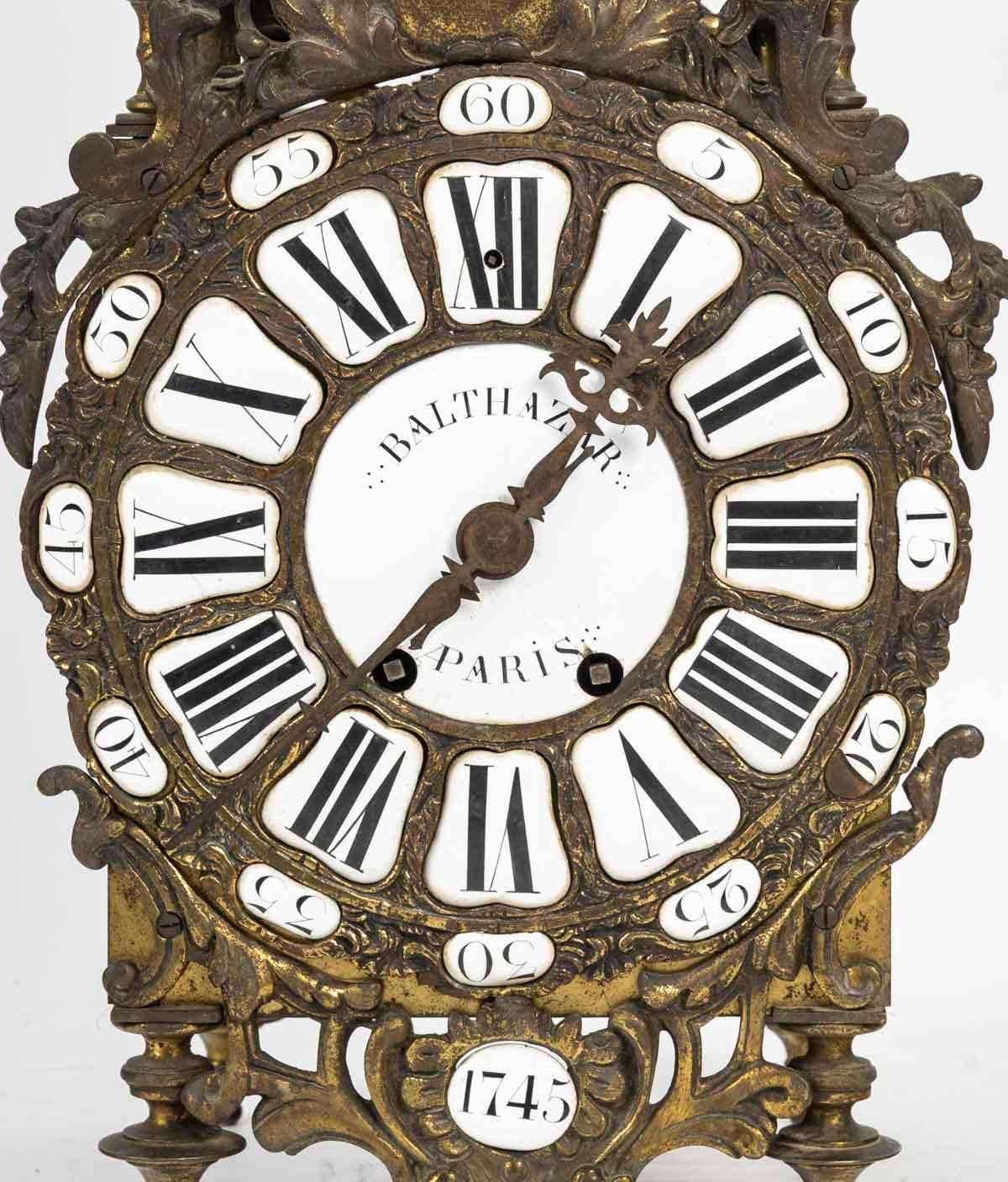18th century bell clock, mechanism signed by Huy Angers.

Bell clock signed by Balthazar, Paris, 1745, mechanism signed by Huy Angers, 18th century in brass and enamel plate.
H: 51cm, W: 23cm, D: 18cm