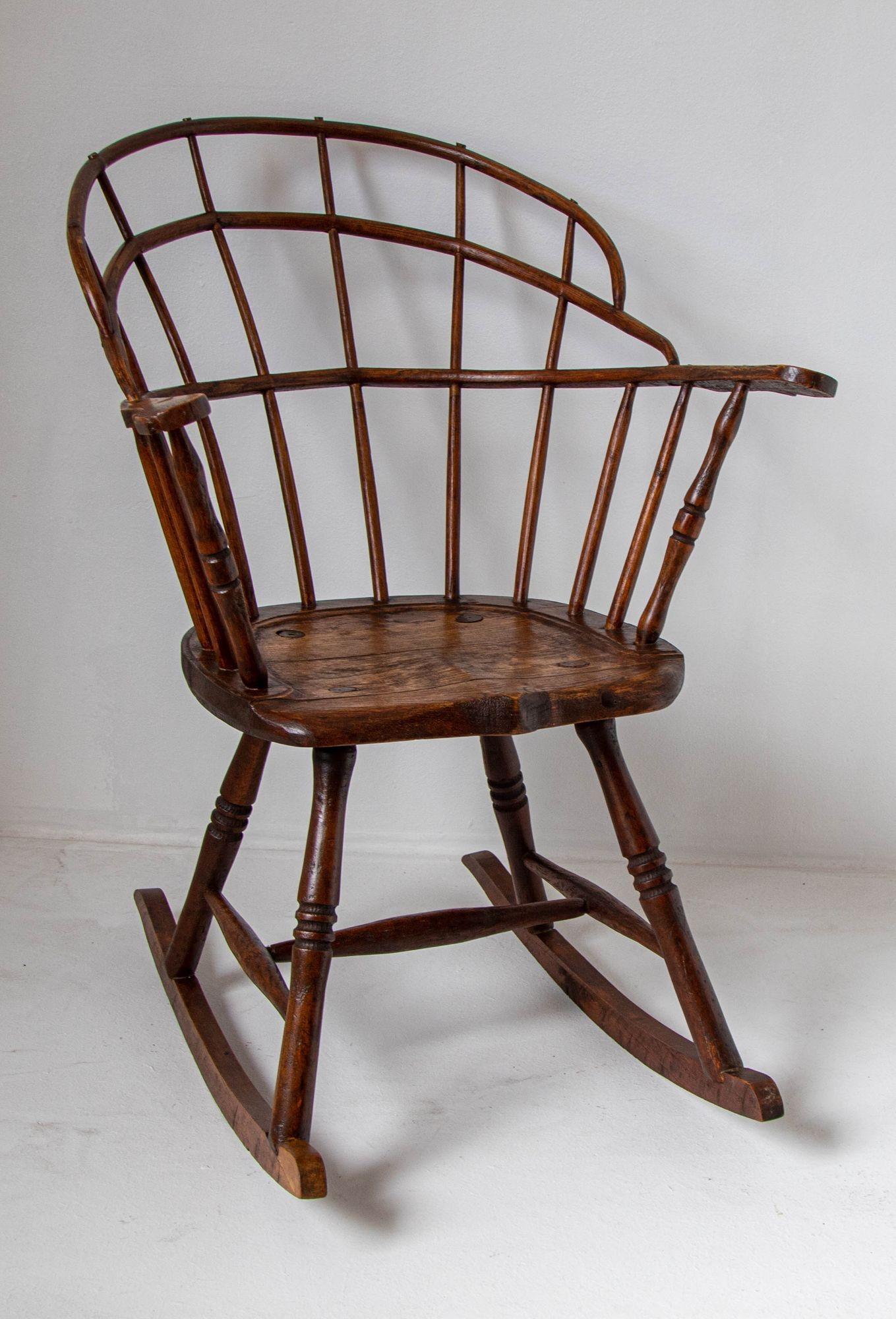 18th Century Bentwood Windsor Fan back Rocking Chair.
An interesting late 18th century elm Sack-back Windsor Rocking Chair.
Interesting and rare continuous bentwood fanback construction, outward-curving spindles, bowed arm rest terminating in webbed