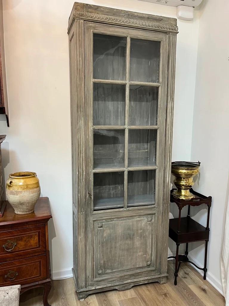 18th Century bibliothèque bookshelf cabinet, likely Swedish, the clean lined top over guilloche molding over a single door having eight lights flanked by stop reeded, molded case, the lower panel of the door having rosette details, the sides carved