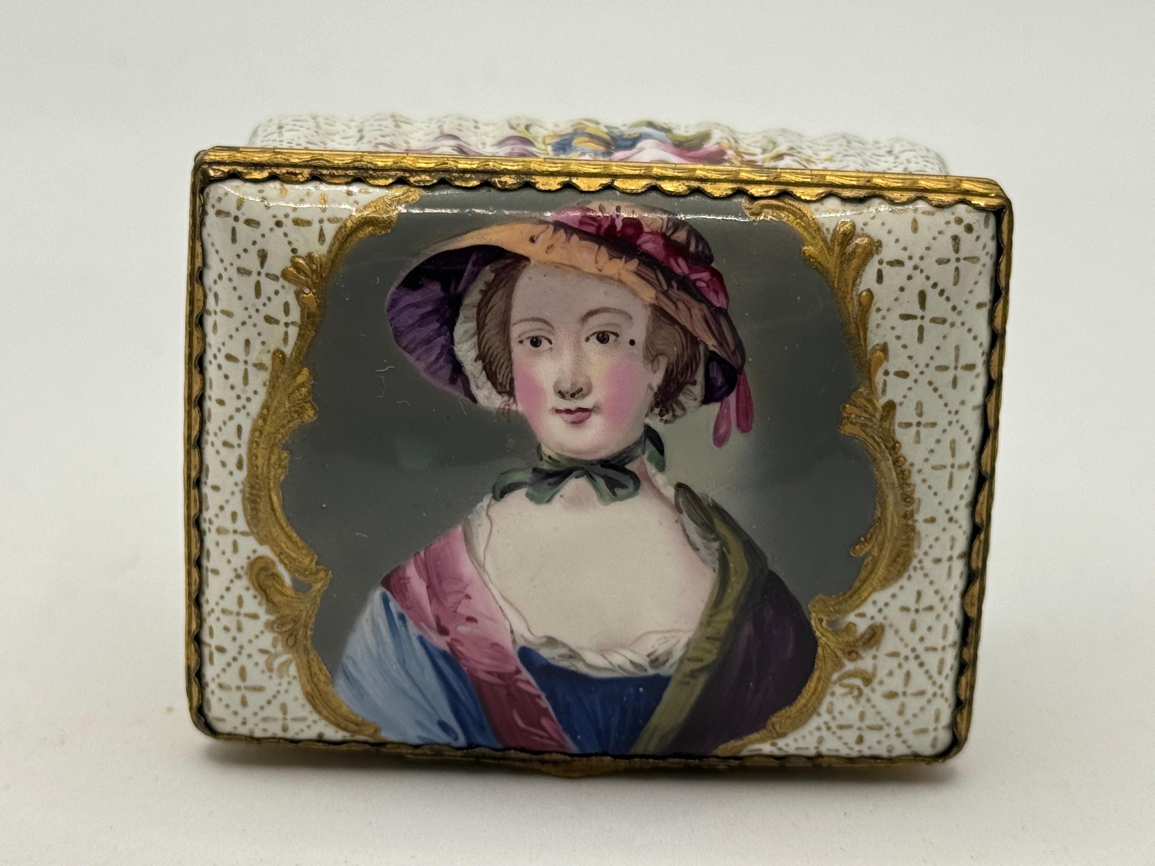 18th Century Bilston Enamel Rectangular Patch / Snuff Box Circa 1780, white with hand-painted floral motifs around edges and base, and a central scene of a lady in hat, white interior.

32mm high x 65mm wide x 50mm depth     
