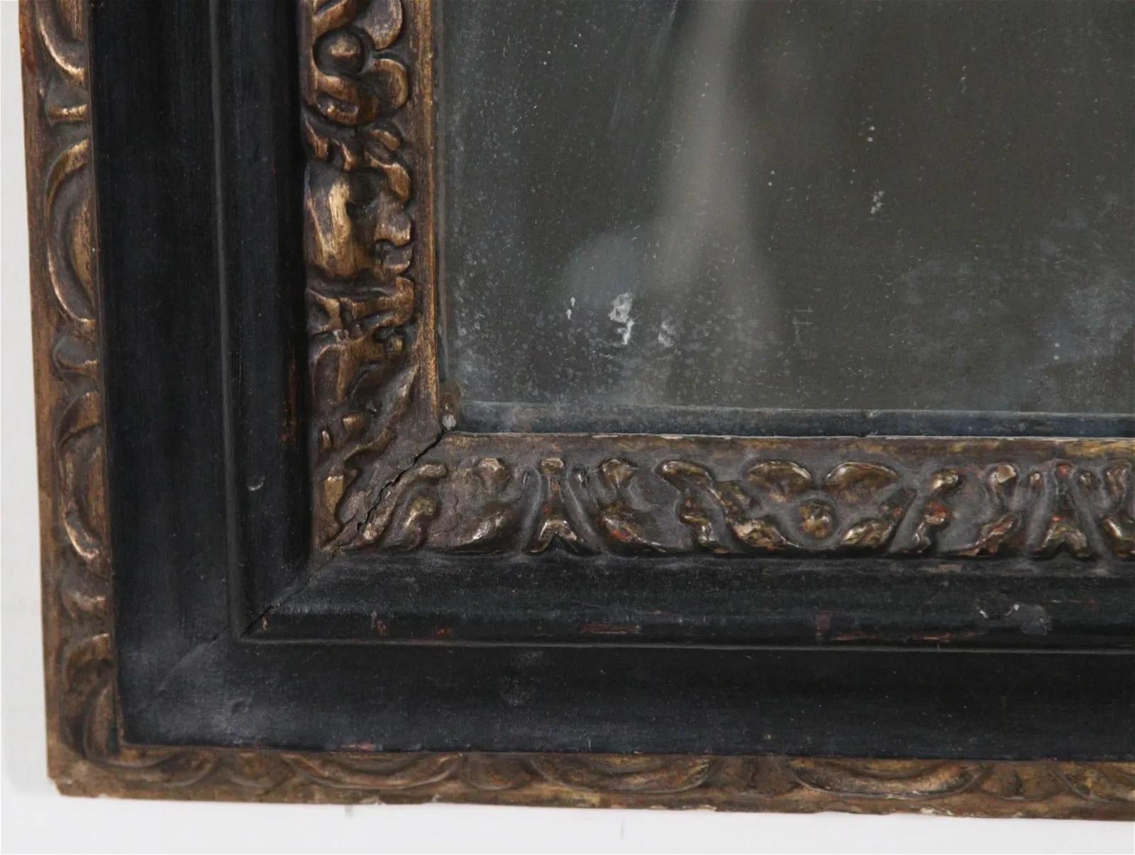 Miroir baroque du 18ème siècle avec cadre noir. L'élégant cadre est orné à l'intérieur d'une feuille d'acanthe dorée et à l'extérieur d'un motif d'œuf et de fléchette doré. Il est orné de magnifiques sculptures et de dorures sur les côtés et sur le