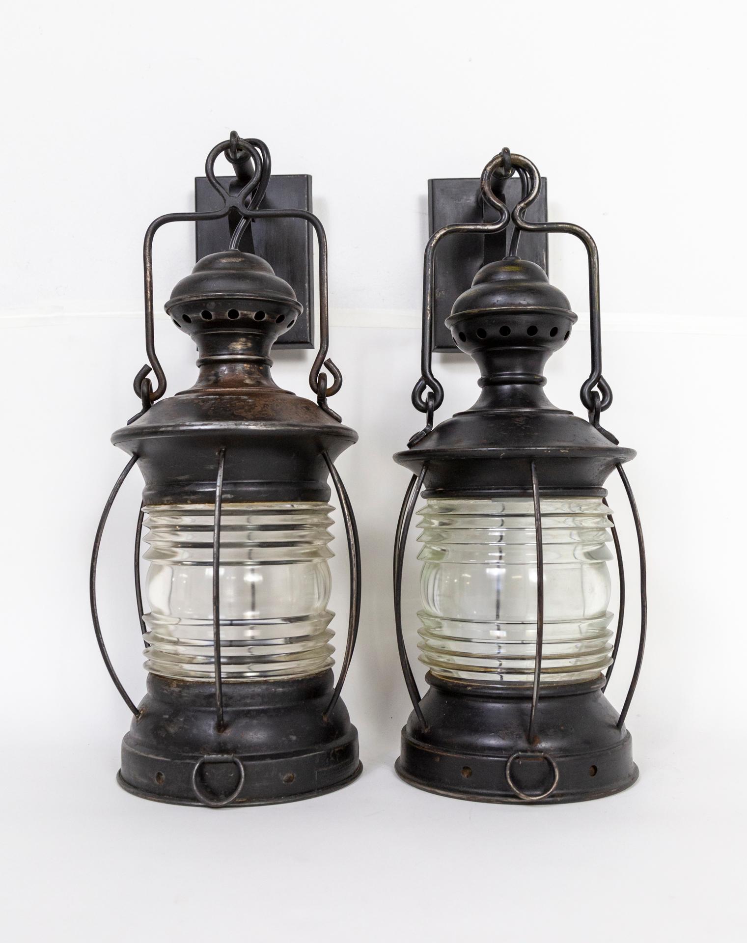 A pair of circa 1880, black painted, nautical lantern wall lights. Newly electrified, originally oil lamps. Measures: 20” height x 8” width x 10” projection.
      
