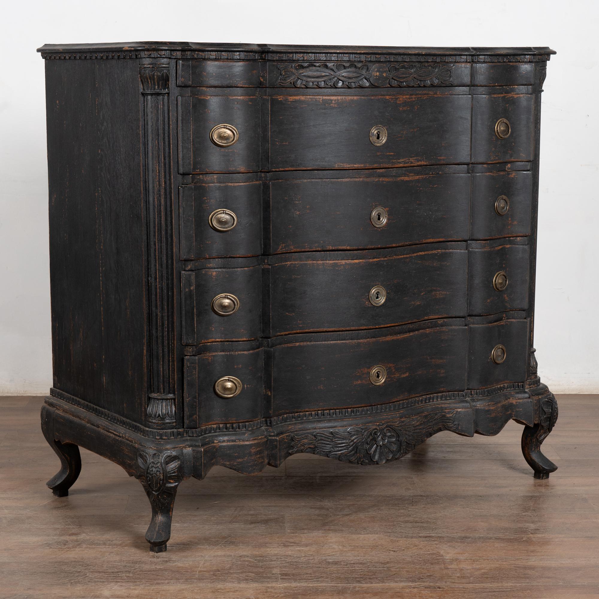 The black painted finish is striking in this attractive large oak chest of four drawers resting on carved scalloped skirt and curved cabriole feet.
While the paint is newer and professionally applied, it compliments the age, rococo style and