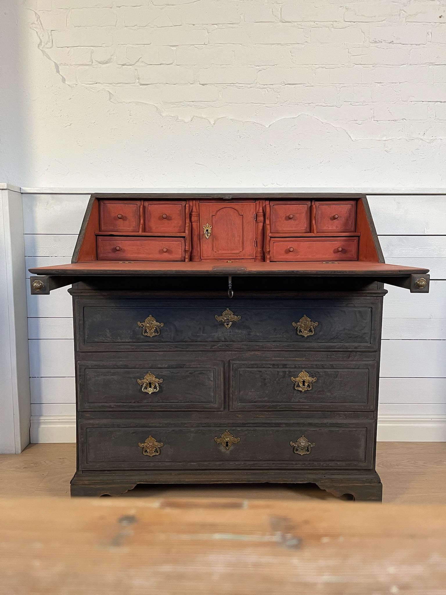 Fold-down flap with hidden drawers, secret compartment and writing interior

Four larger drawers on the lower part of the front. 

Beautiful brass fittings, working lock and keys included

The outside is painted in black, with an antique patina