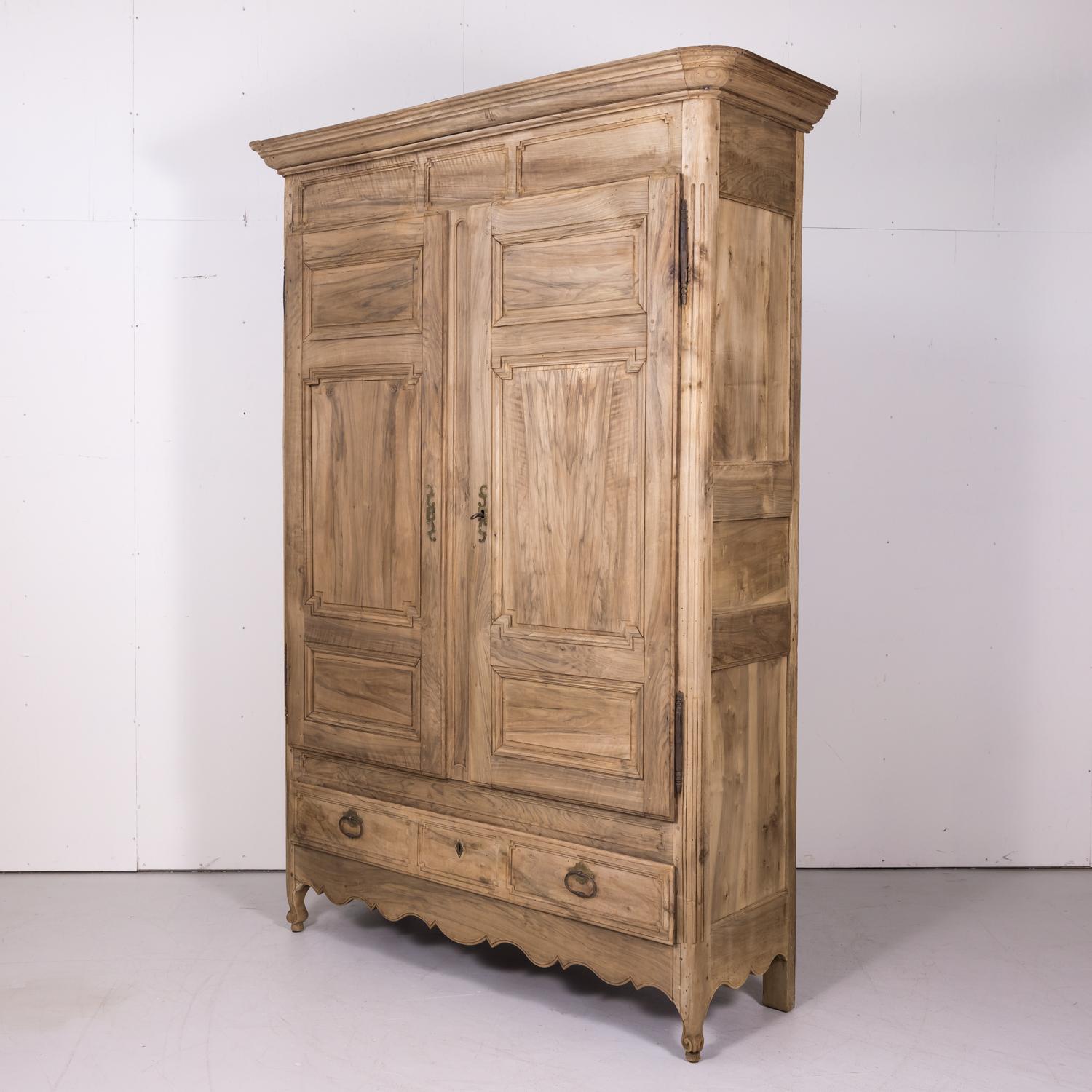 Rare 18th century bleached walnut armoire with bottom drawer handcrafted by skilled artisans in Provence near Arles during the French Transition period (1750-1775). Most Transition period pieces were created outside Paris by Provincial cabinet