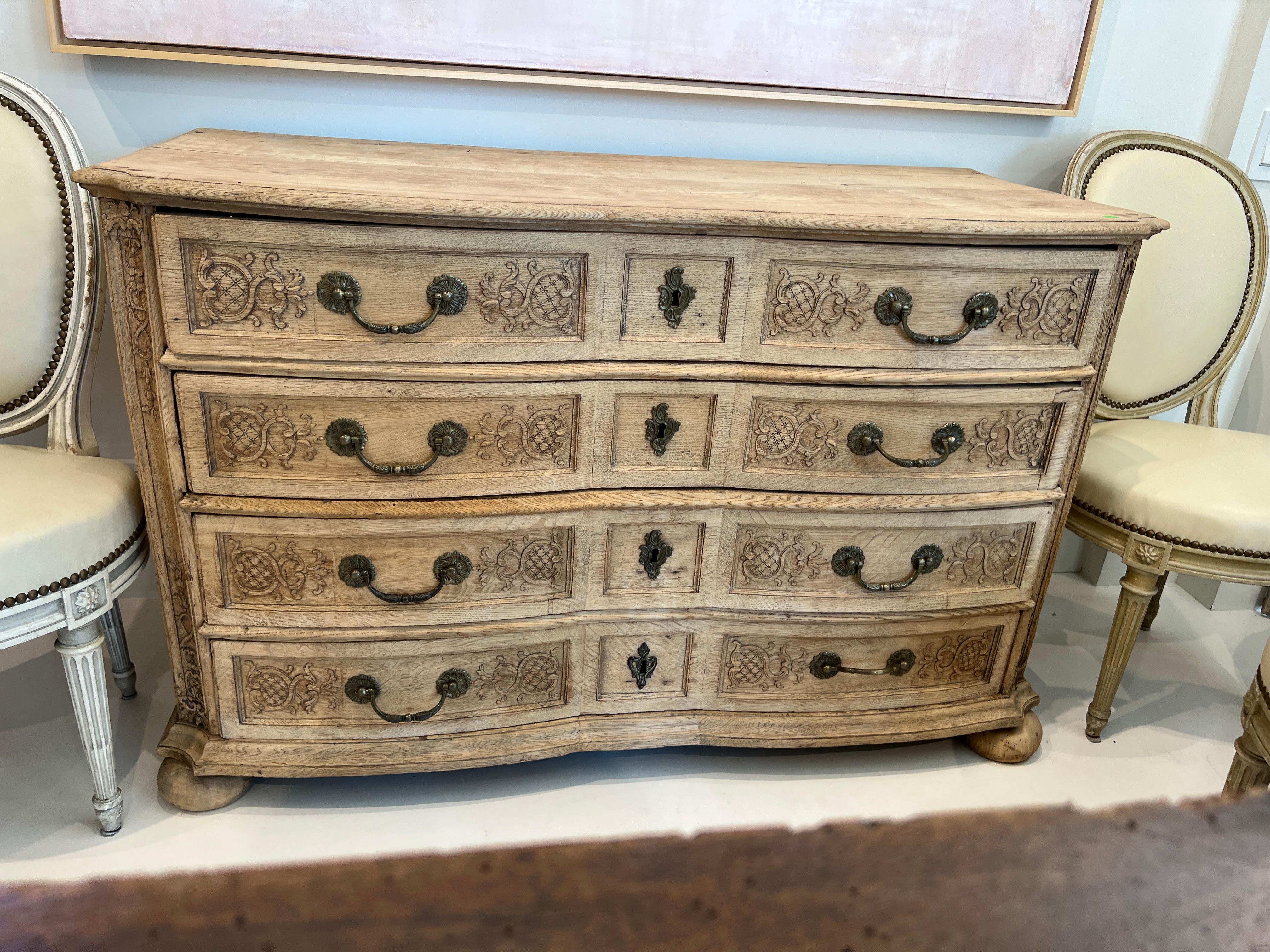 Softly undulating front with so many special details, this 18th century bleached oak chest has a style of carving specific to its town of Liege Belgium. Its pale color allows for the subtly carved details to stand out. The softness theme is repeated