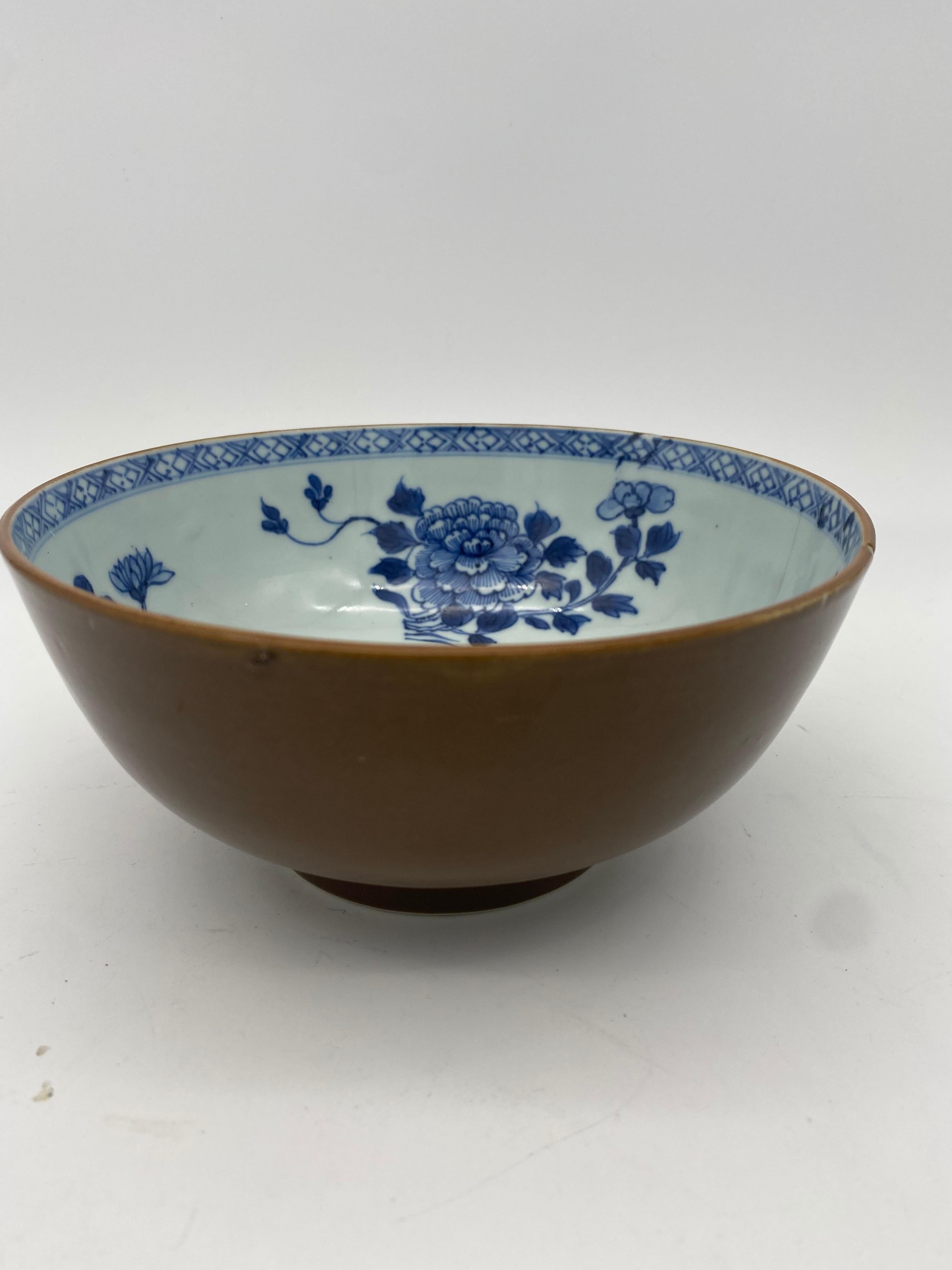 An 18th century Chinese Nanking cargo blue and white and cafe -au-lait porcelain bowl, decorated to the interior with sprays of flowers and leaves, with a continuous cross hatch design to the rim, small crack rim ,with lot label for Nanking cargo,