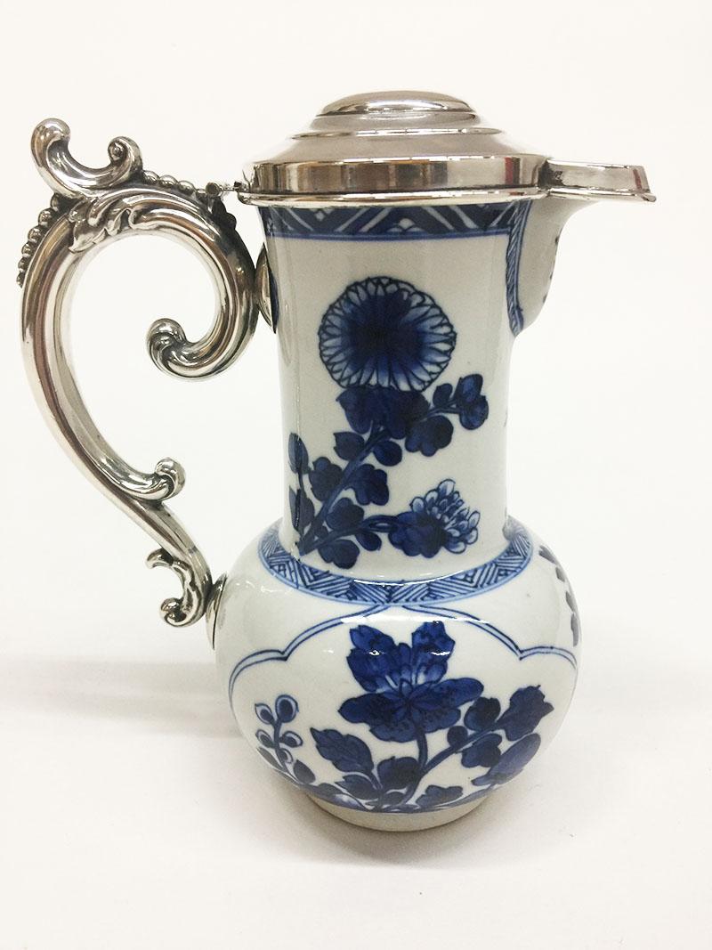 18th century blue and white porcelain and silver Chinese jug, Kangxi, 1662-1722

18th century blue and white porcelain Chinese jug??With silver handle and lid in a beautiful dark blue color with floral decor.
The silver was made in the 19th