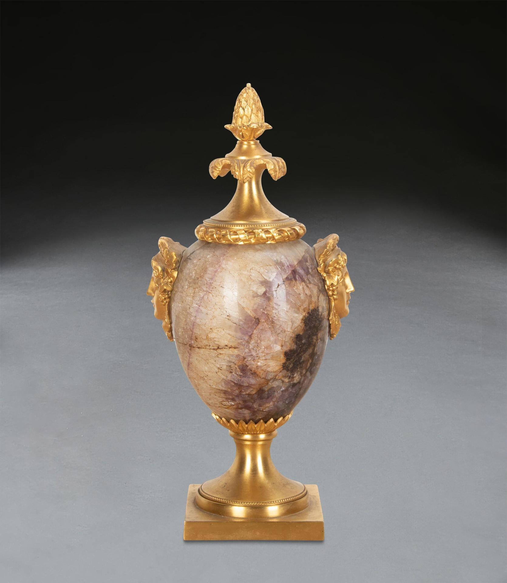 ﻿ A wonderful late C18th Ormolu mounted Blue John urn, attributed to the workshop of Matthew Boulton. The acorn finial with rope twist border, above pale veining and rich purple marble, with bold female masks to the sides, over palmette apron with