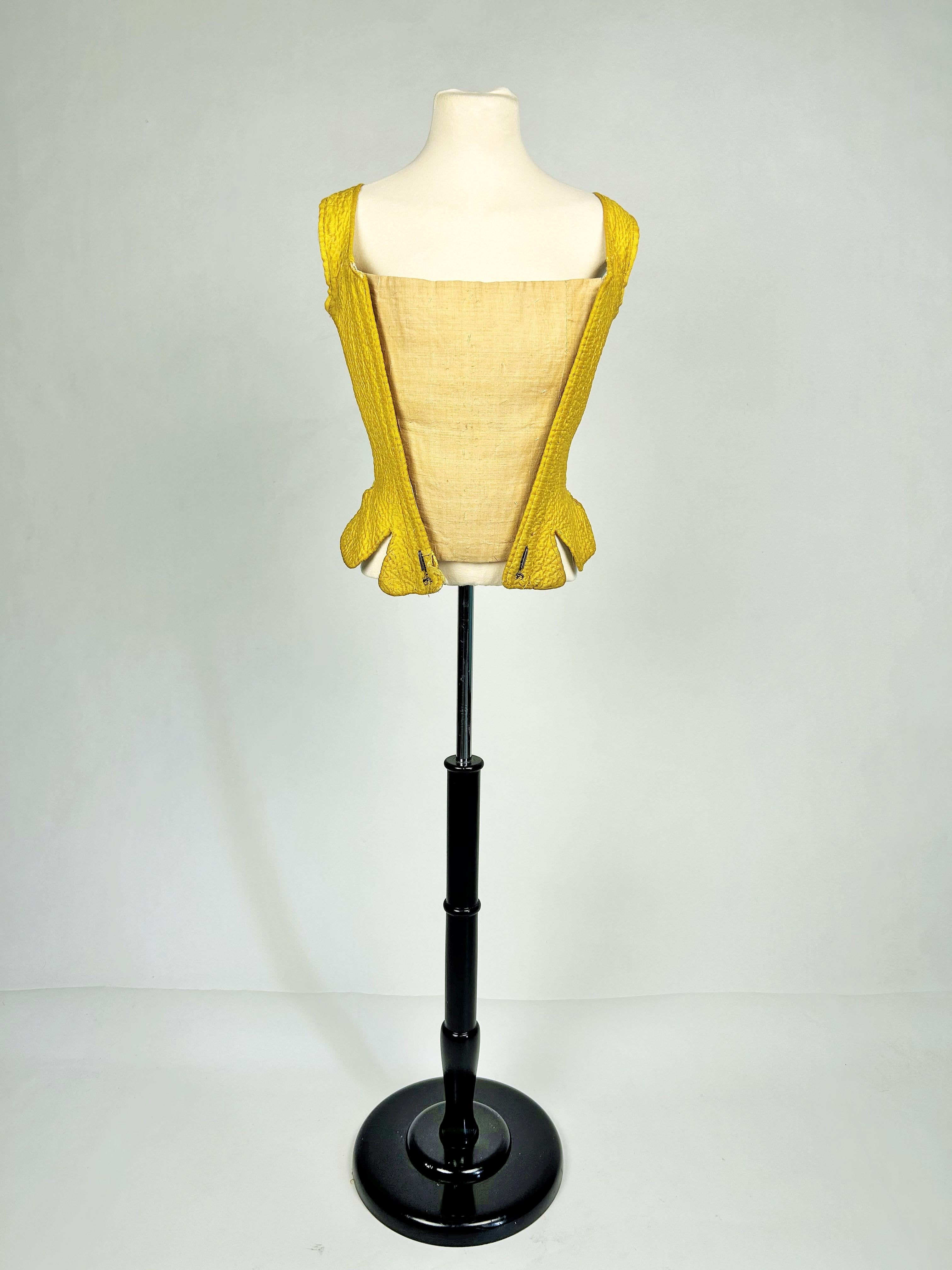 Circa 1770
France - Provence
Lady's bodice stay entirely quilted with yellow silk taffeta and Rouenneries dating from the end of the Louis XVI period. Semi-rigid bodice with linen yoke to position a stomacher piece on the front, and six whalebone
