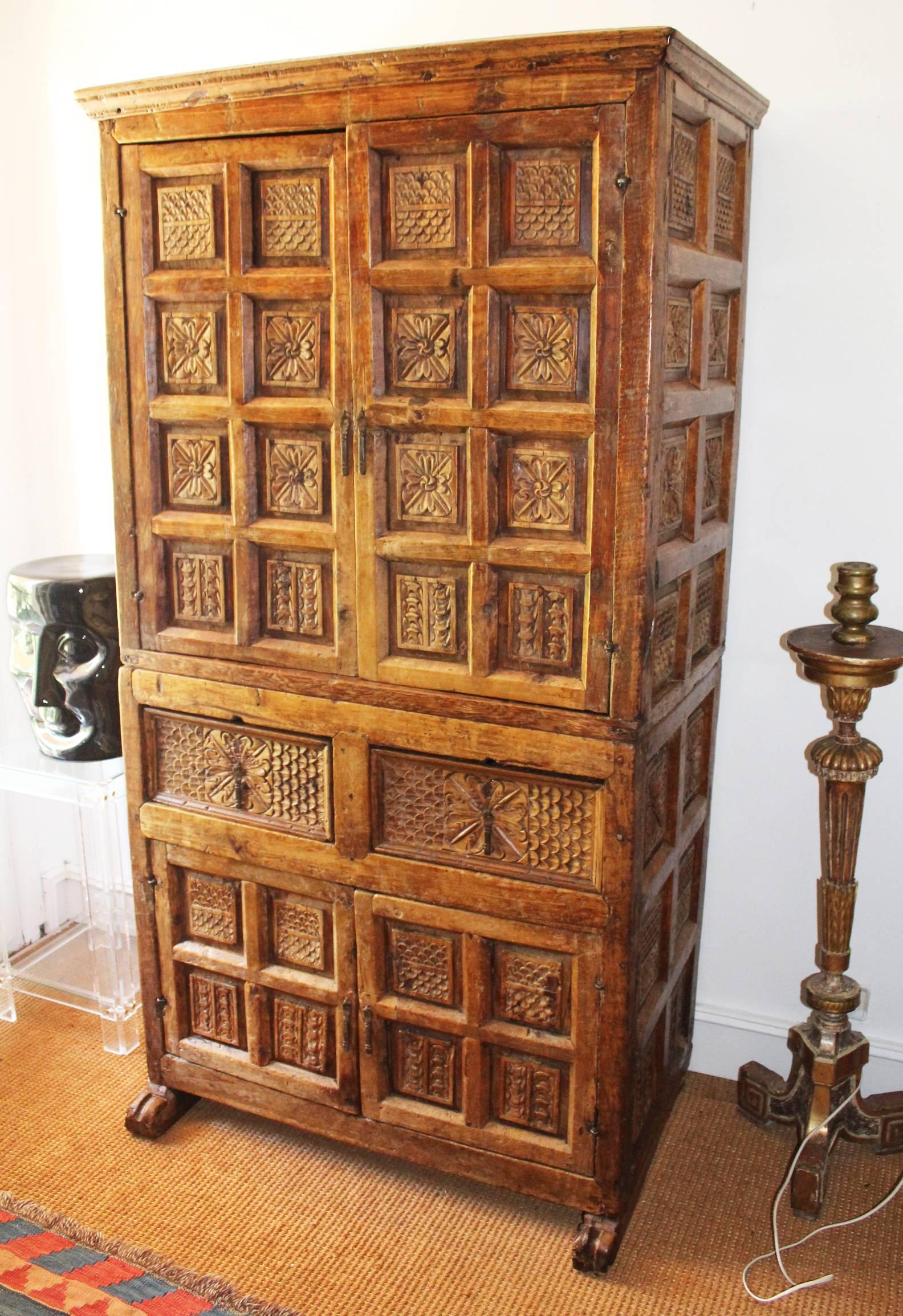 Kolonialer Schrank aus bolivianischem Fruchtholz des 18. Jahrhunderts, handgeschnitzt mit klassischen geometrischen Mustern und floralen Motiven, die die vier Türen und zwei Schubladen sowie die Seitenwände bedecken.
  