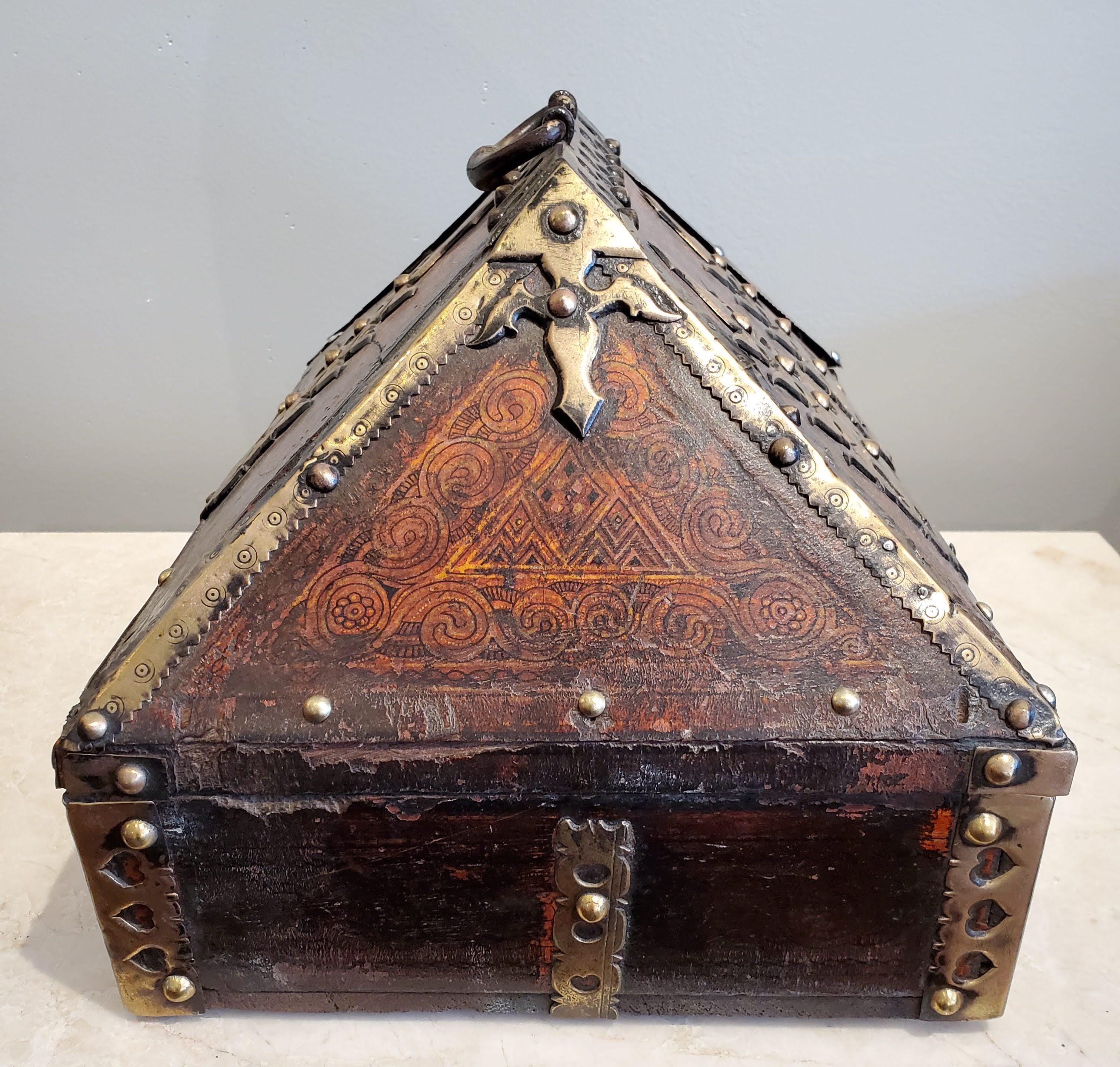 Questo bellissimo cofanetto per la dote matrimoniale della fine del XVIII secolo è uno squisito esempio di artigianato indiano. Realizzato in teak con superficie laccata rossa patinata, intricata lavorazione a penna e ottone decorativo. Questo pezzo