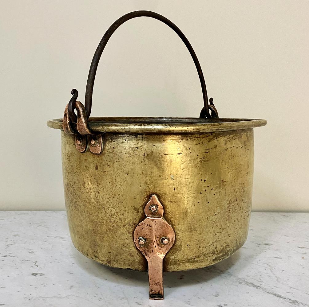 18th century brass and copper hand forged stock pot recalls a bygone era when such vessels were laboriously handmade by talented artisans using techniques handed down from generation to generation. This example features a brass pot with rolled edges