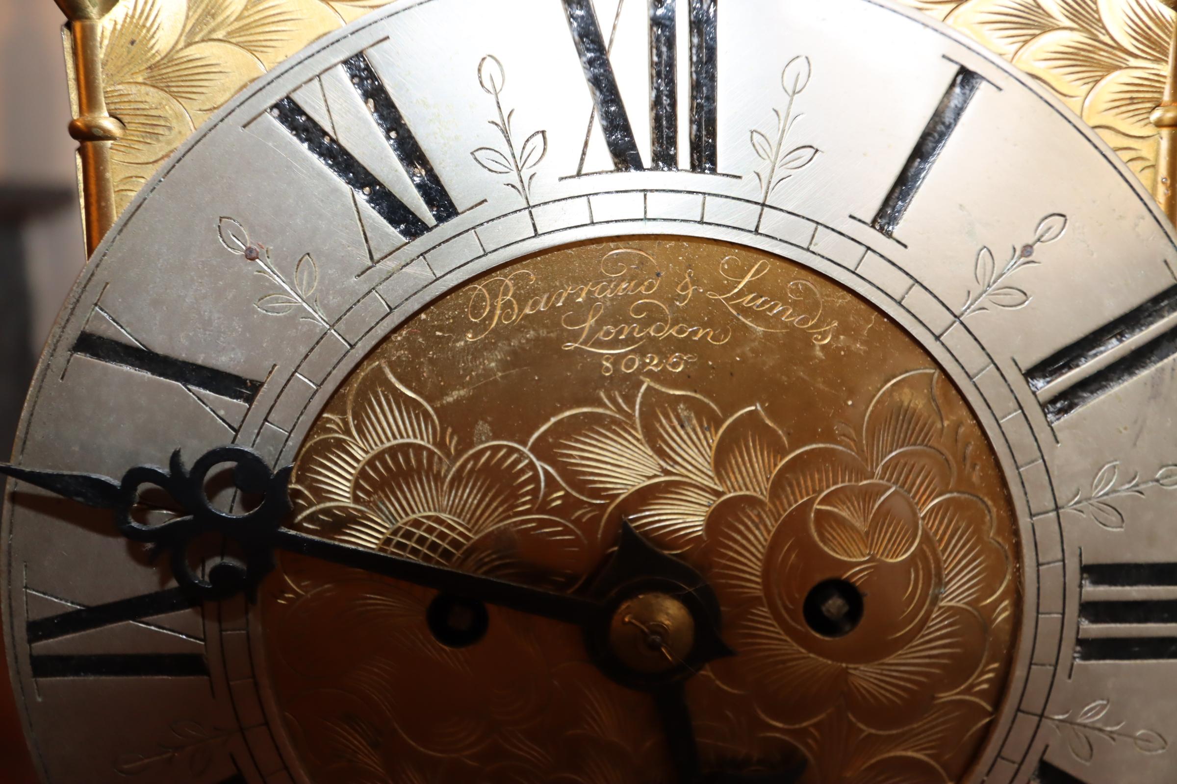 Eine exquisite Laternenuhr aus Messing aus dem 18. Jahrhundert, eine meisterhafte Verbindung von Eleganz und Funktionalität. Der aus glänzendem Messing gefertigte Zeitmesser ist mit filigranen Laubsägearbeiten versehen, die den laternenförmigen