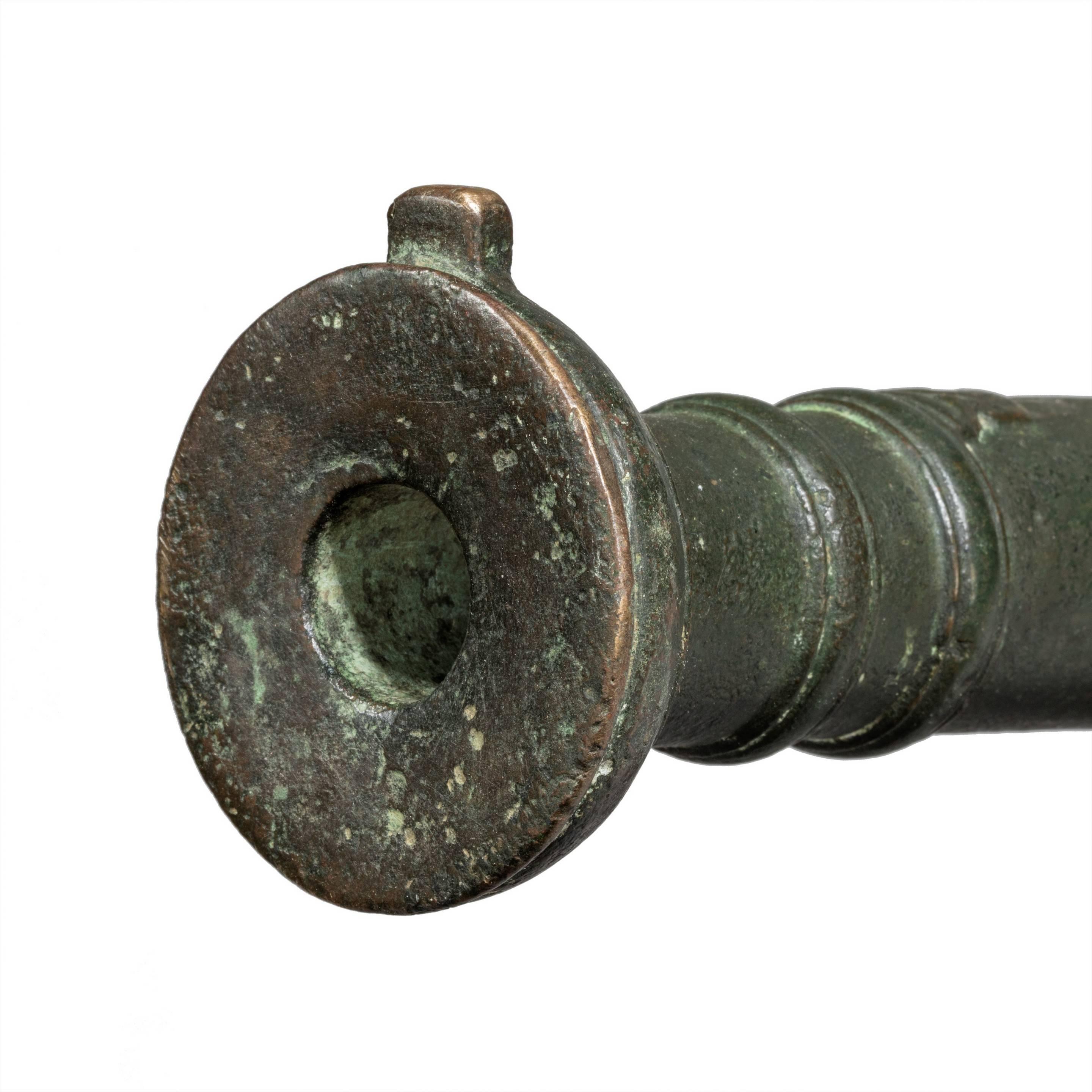 A late 18th century Lantaka bronze cannon barrel with flared barrel and typical decoration.

Now hinged on an iron stand.