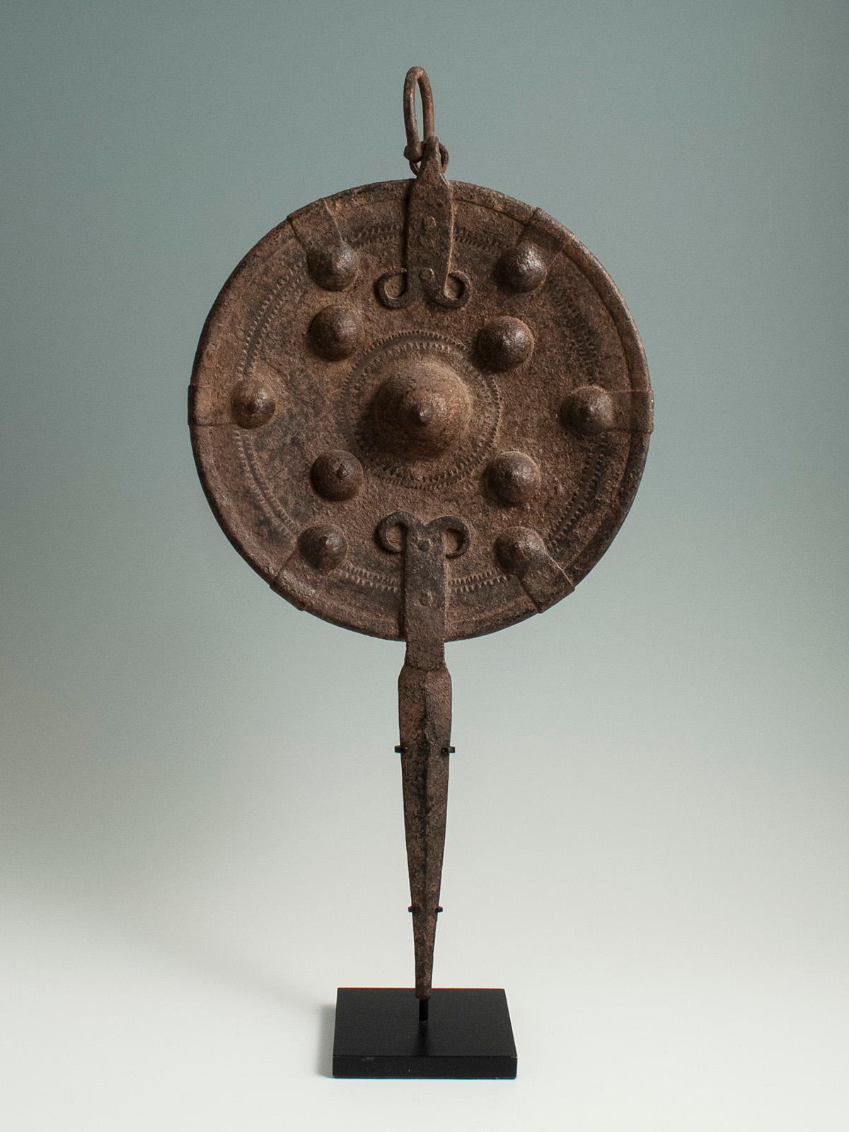 18th Century Iron Buckler Parrying Shield, Santal Region, Northern India

A small yet stately iron parrying shield from the Santal region of Northern India. The ten conical domes may be brass or iron, and the surface is covered overall with an