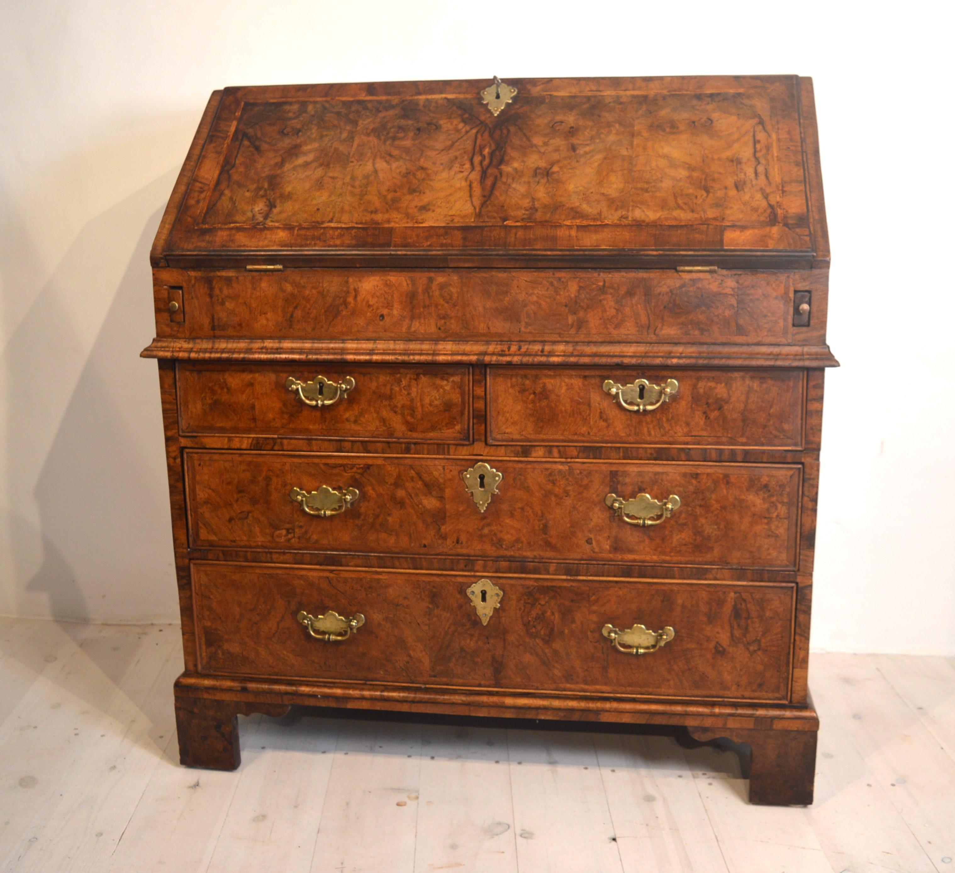 Here we have a very good quality early 18th century burr walnut bureau, with a well and stepped interior, a door and drawers on the inside.  Sitting on bracket feet it  also has a cross-cut waist moulding and the veneer is herringbone inlay .The