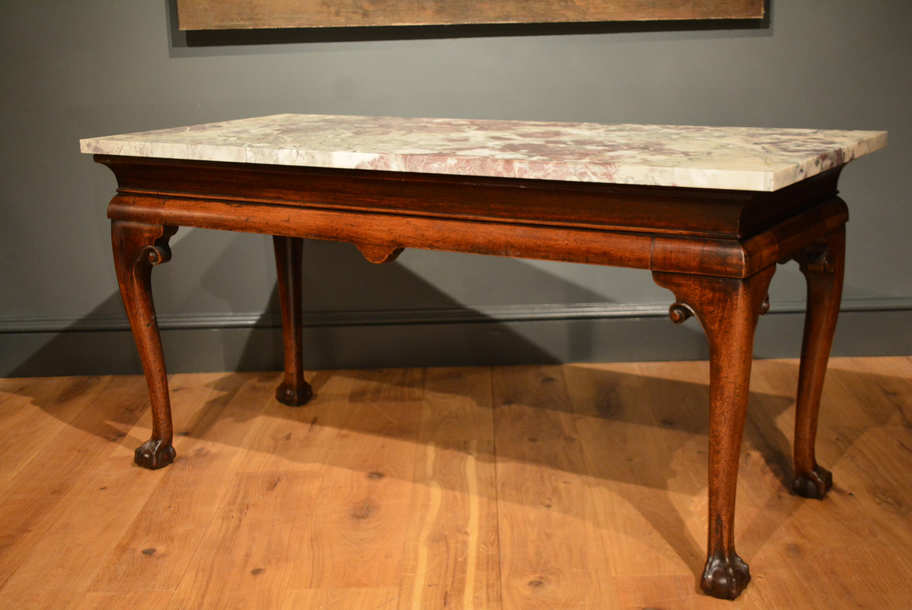 A large George II mahogany cabriole leg marble-top side table, the legs with scrolling ears and claw and ball feet.