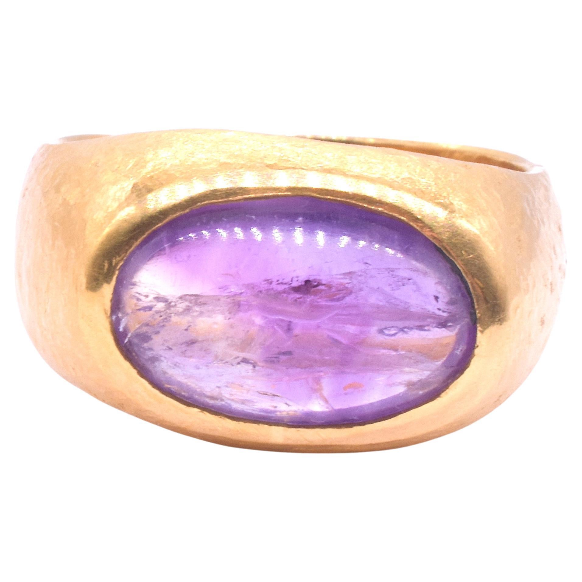 We love the patina of this antique delicate carved amethyst intaglio depicting a charming bird perched on solid ground, beak pointed upward mounted in a later, retro hammered 24K gold band.  The ring is substantial at .38 inch high but not