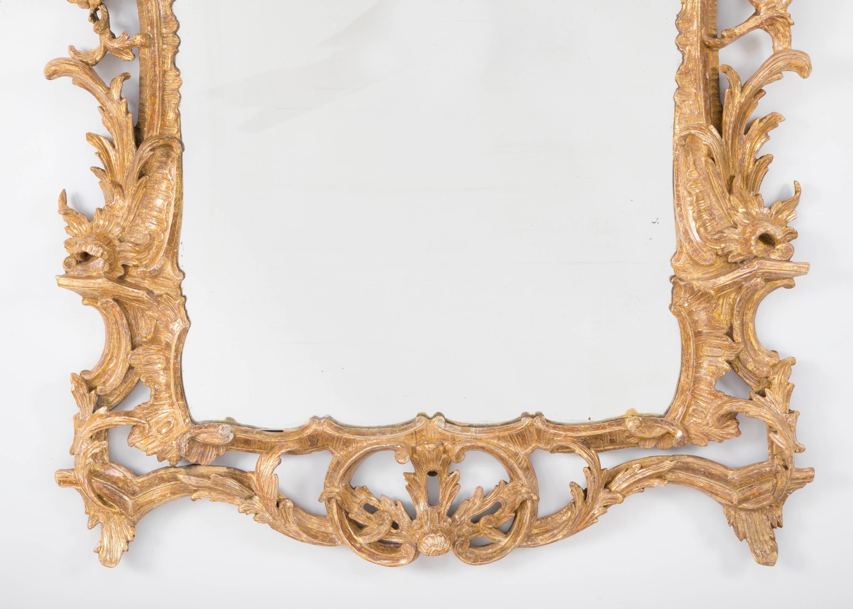 A very fine English George III Chippendale carved and gilt wood mirror, retaining its original gilding. Delicate and robust openwork carving throughout. The warm gilt wood surface of this mirror is exceptional. Large-scale at 63 inches high. The