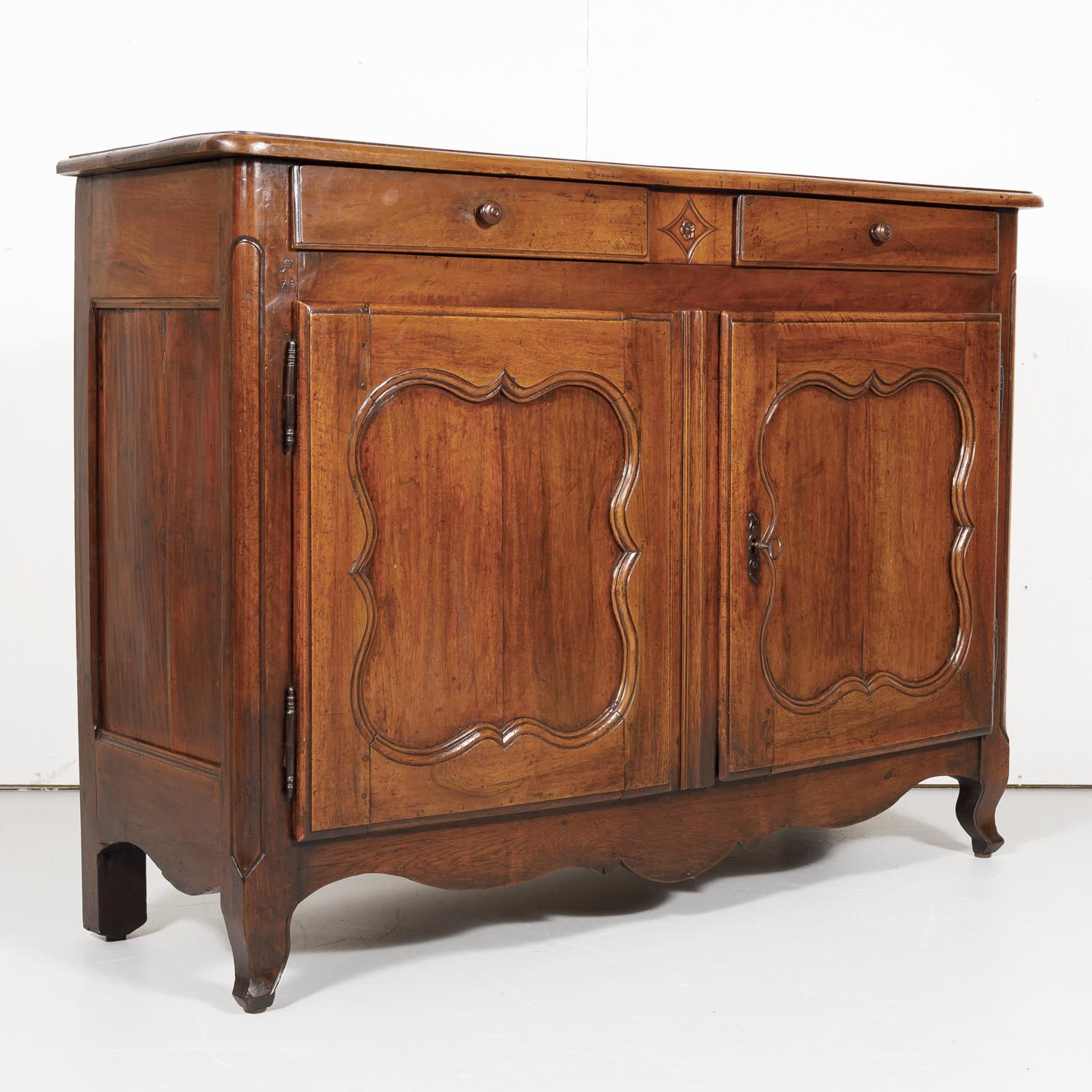18th century Country French Louis XV period buffet handcrafted of solid walnut by craftsmen in Bordeaux having a beveled, two plank rectangular top above two frieze drawers and two lower doors that open to reveal ample storage, circa 1750s. Simple,