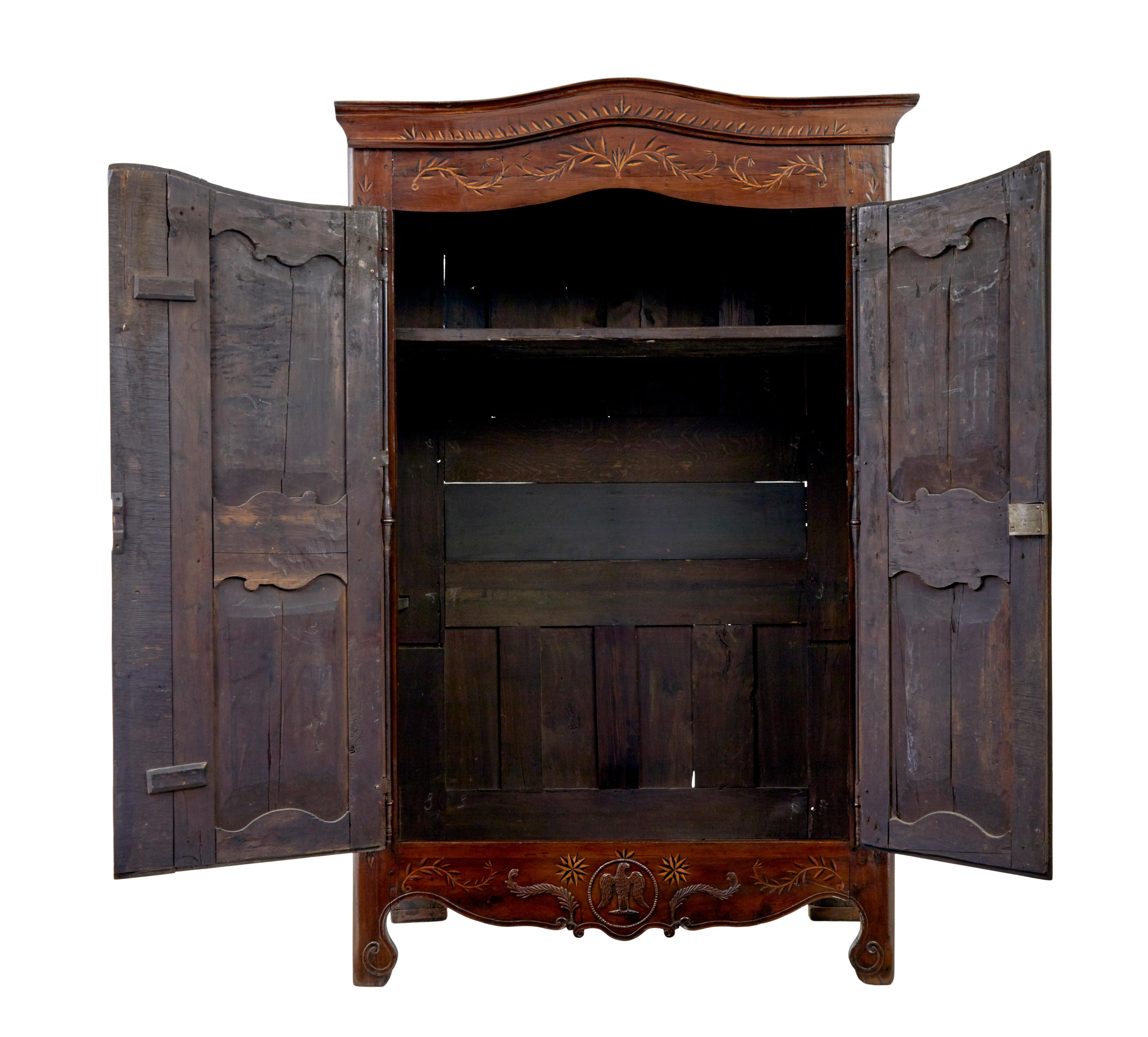 18th century carved french yew wood and chestnut armoire circa 1780.

This sort of armoire is also known as a marriage armoire.

Cornice and front are profusely inlaid with a leaf design, with a snake flowing up the middle of the doors, with pierced