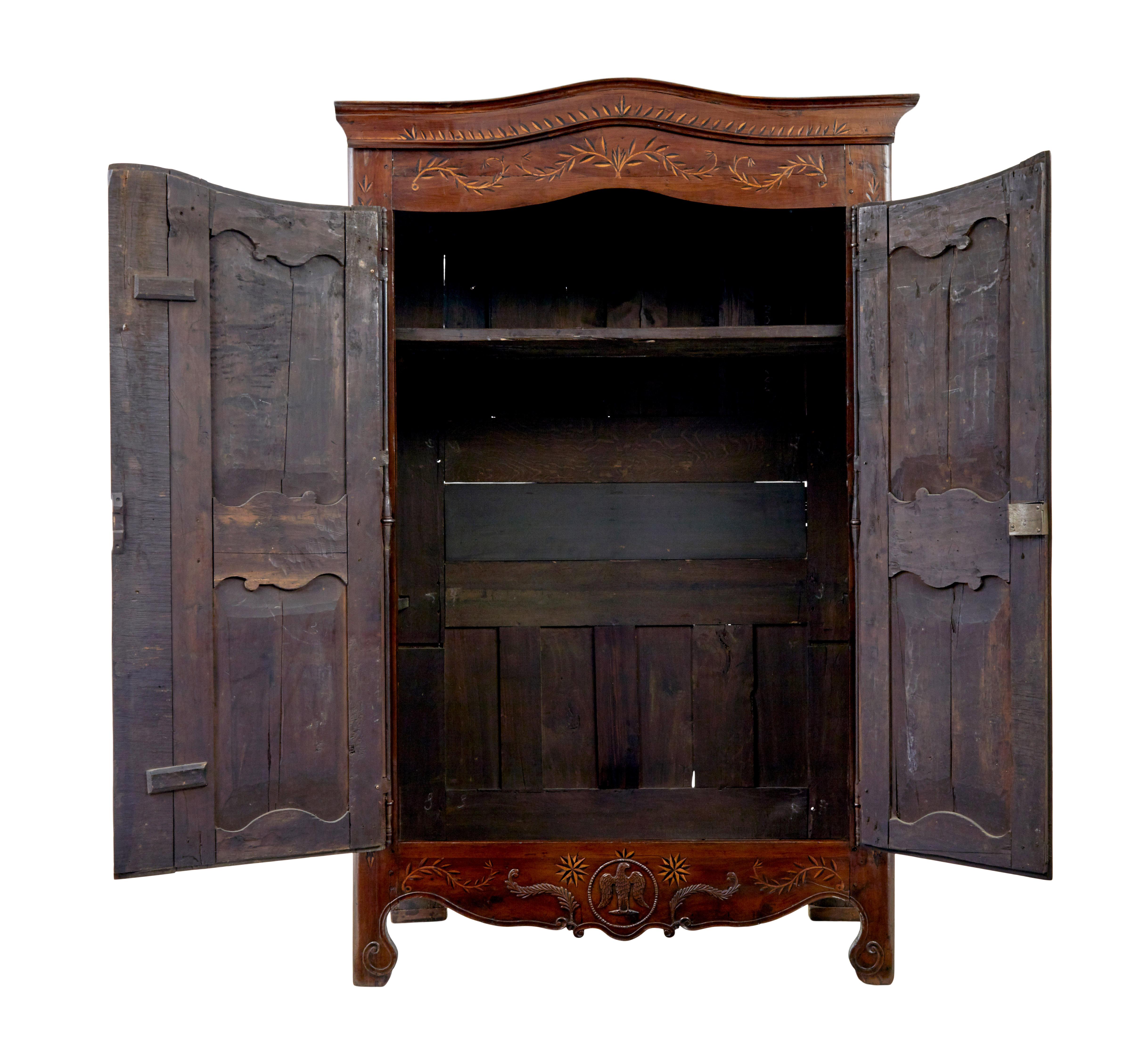 18th century carved french yew wood and chestnut armoire circa 1780.

This sort of armoire is also known as a marriage armoire.

Cornice and front are profusely inlaid with a leaf design, with a snake flowing up the middle of the doors, with pierced