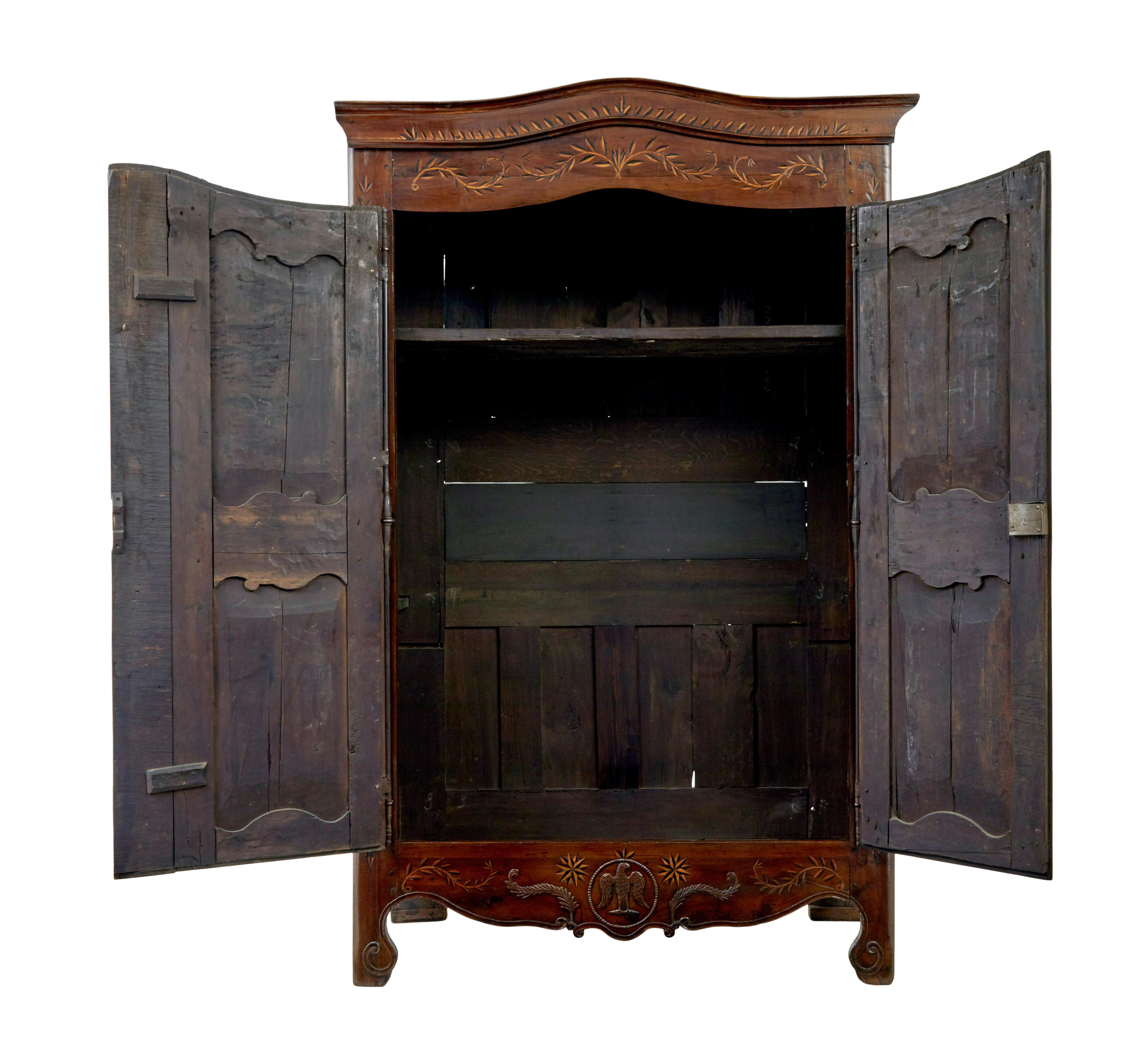 Armoire française du 18�ème siècle en bois d'if et châtaignier sculpté vers 1780.

Ce type d'armoire est également connu sous le nom d'armoire de mariage.

La corniche et la façade sont abondamment incrustées d'un motif de feuilles, avec un serpent