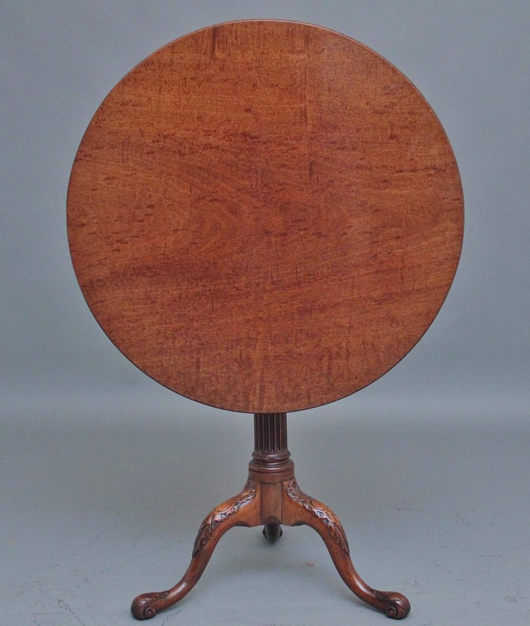 18th Century carved mahogany tripod / wine table, having a lovely figured circular mahogany top supported on a turned and fluted column terminating with three slender shaped legs with decorative carving.  Circa 1780.
