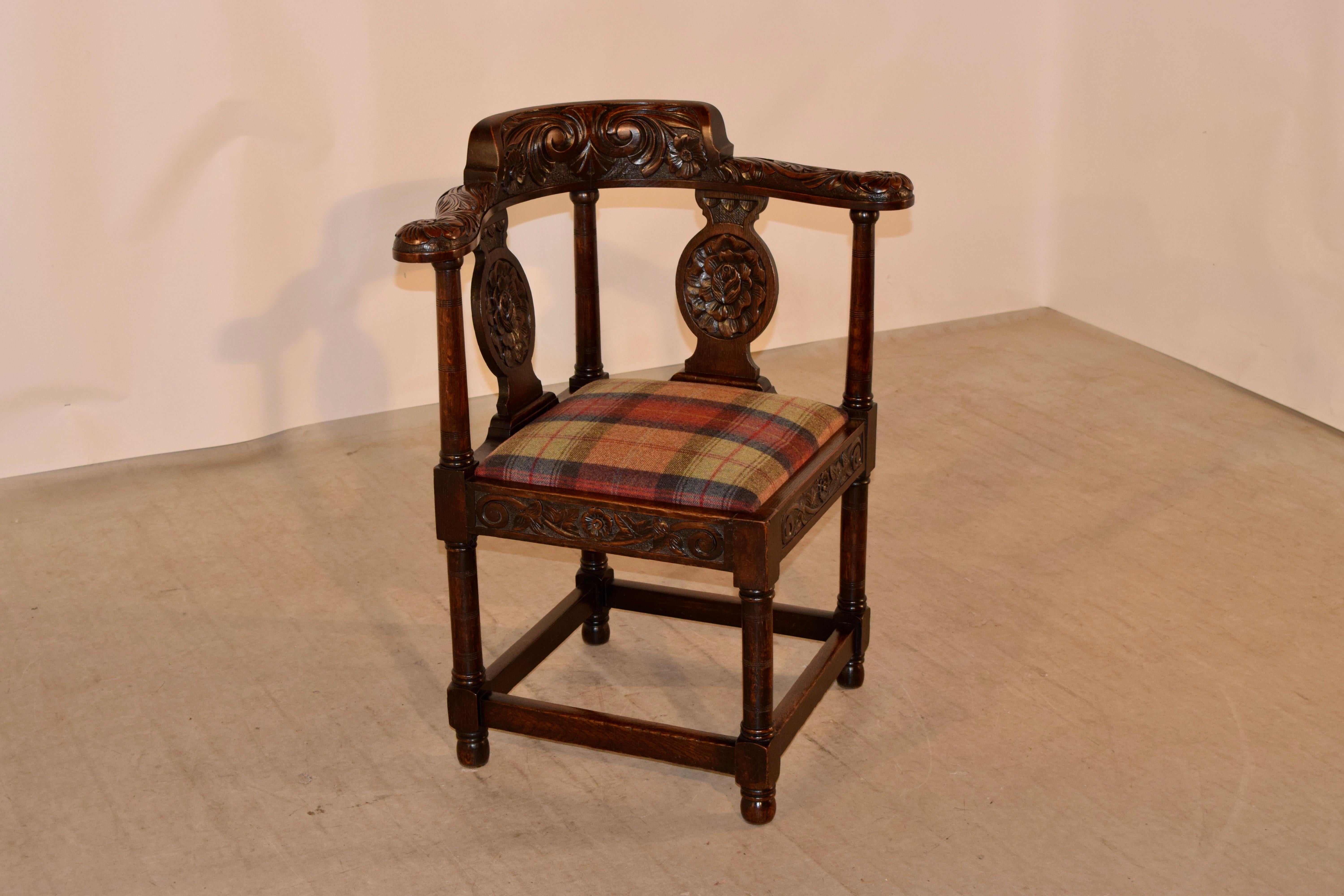 18th century carved oak corner chair from Scotland with a wonderfully carved back, supports and arms, all depicting florals and scrolls.