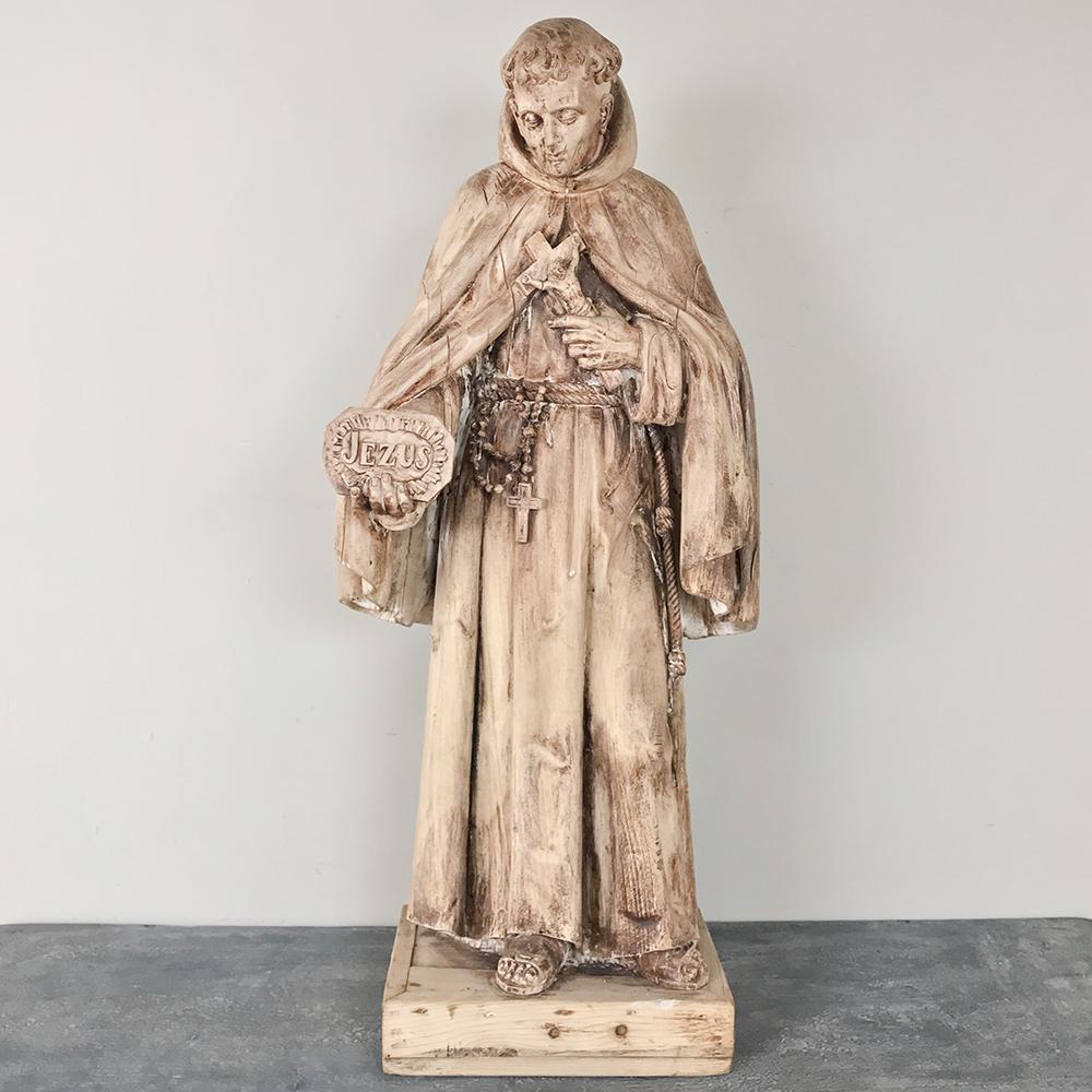 18th century carved wood statue of Saint has been carved with the figure in the raiment of a Monk holding a plaque with the name of Jesus inscribed into it. The classical pose, weathered finish, and medium size make this an especially appealing