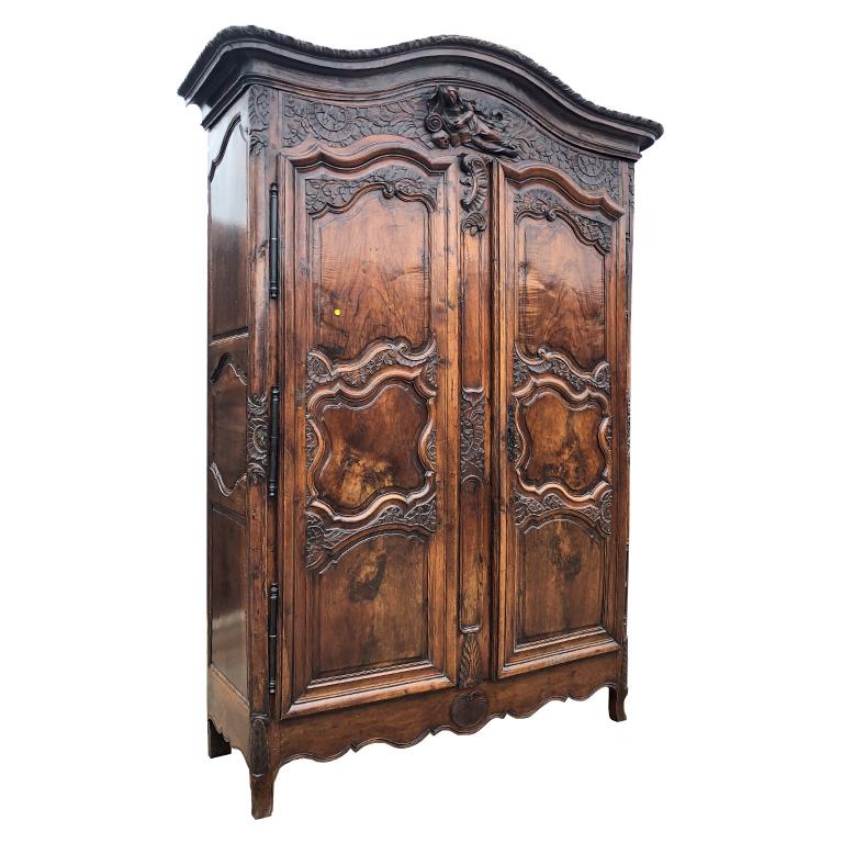 Standing at nearly nine feet high, this rare solid wood armoire or Buffet de château originating from the 18th century is an excellent example of French furniture during the 1700s. With a wonderfully rich patina, this large beautiful piece features