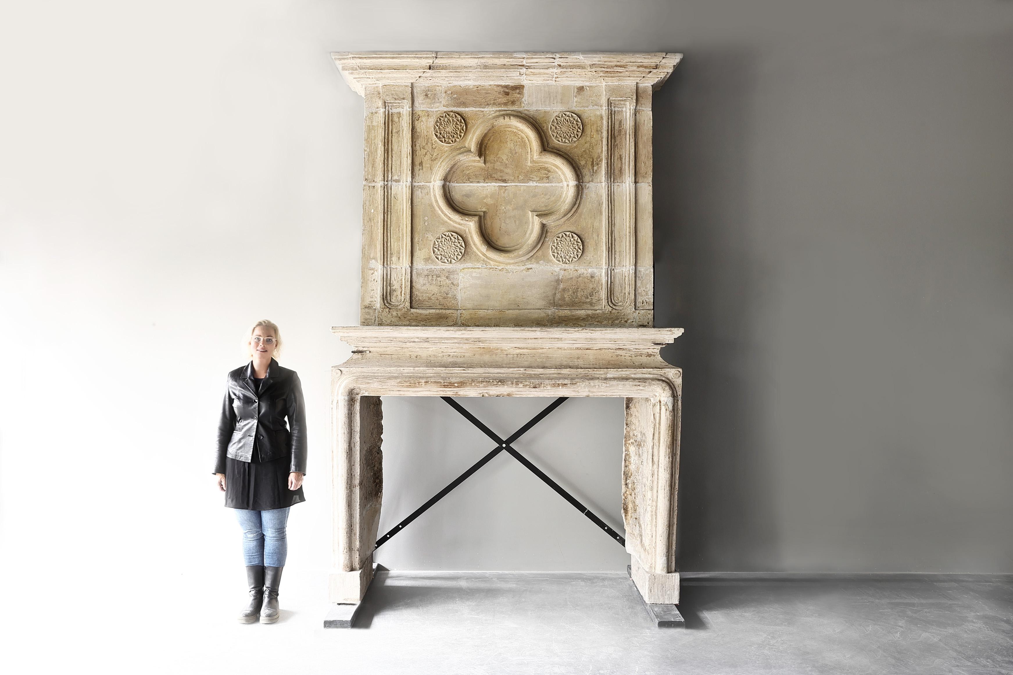 Step into the opulence of the 18th Century with a magnificent Louis XIV fireplace adorned with a striking trumeau on top, crafted from exquisite French limestone. This antique mantelpiece exudes a timeless grandeur that captures the essence of a