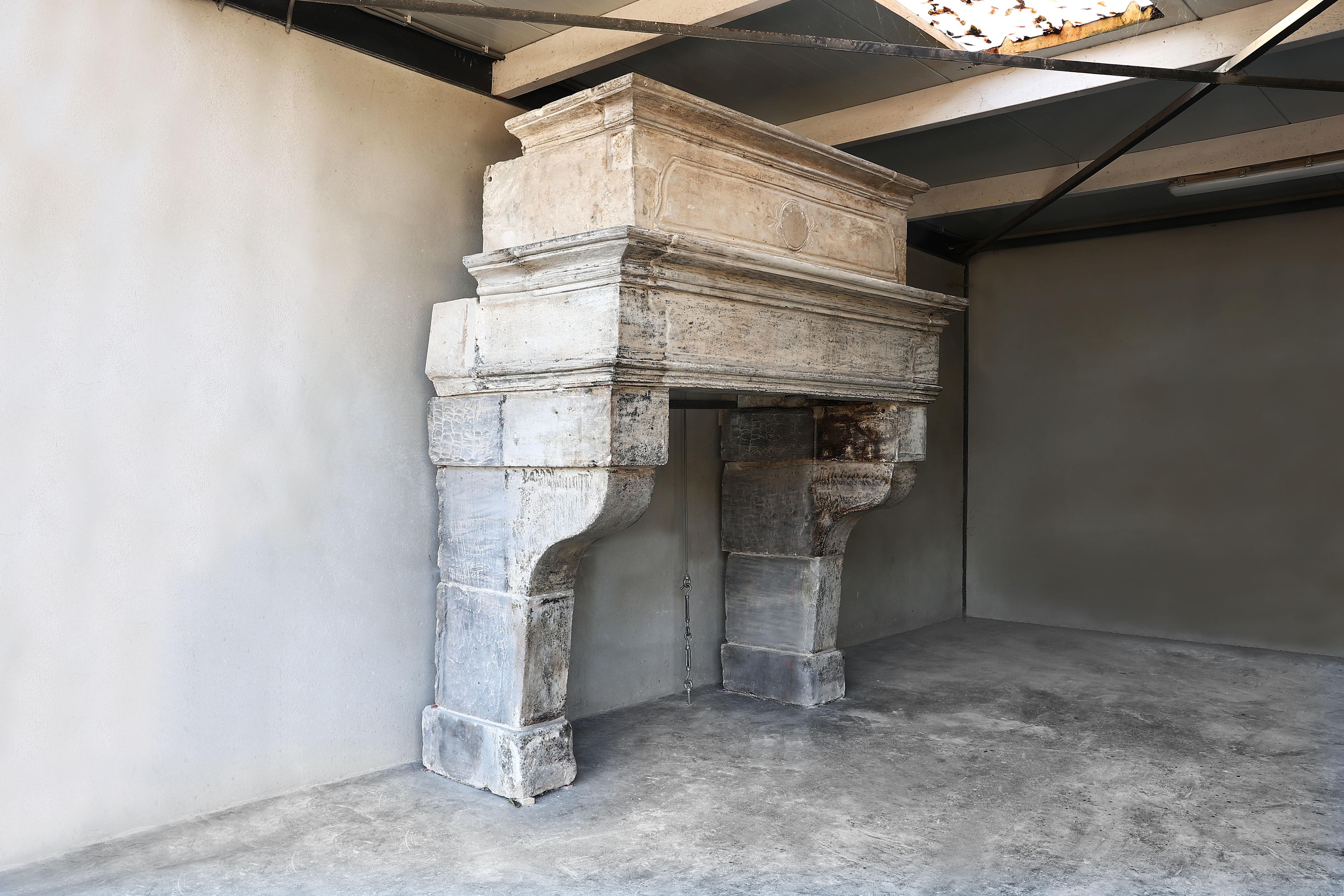 Imposing castle fireplace with trumeau of French limestone from the 18th century in style of Louis XIII. A fireplace with history and allure! We got this fireplace from a castle in the Burgundy region. A rustic coat with beautiful lines and a robust
