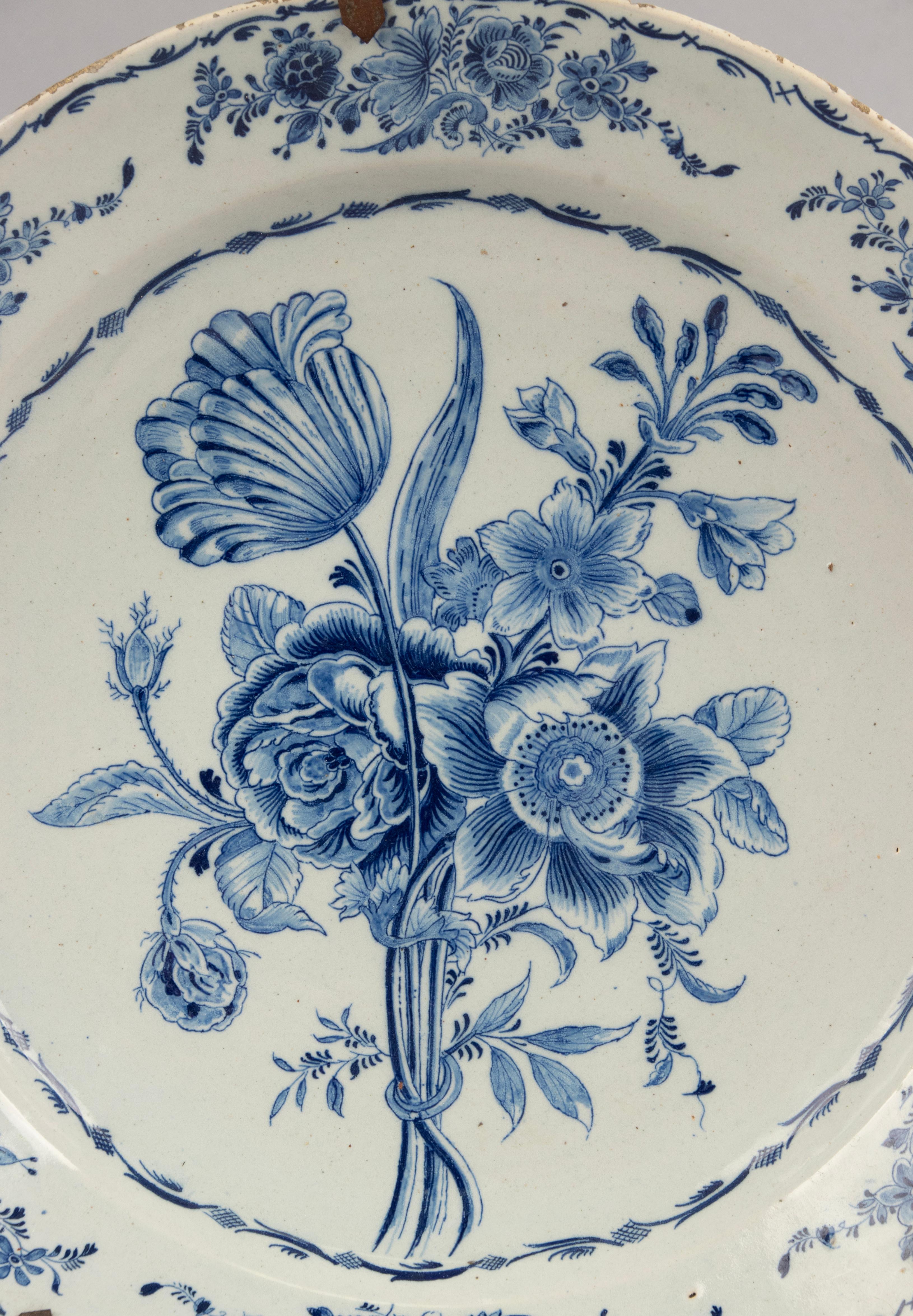 A beautiful 18th century Delft ceramic wall plate. Decorated with flowers. 
The plate is not marked, maker unknown. 
The plate is in good condition with signs of use, some wear at the glaze on the borders.

Dimensions: the plate is Ø34,5 cm 
Free